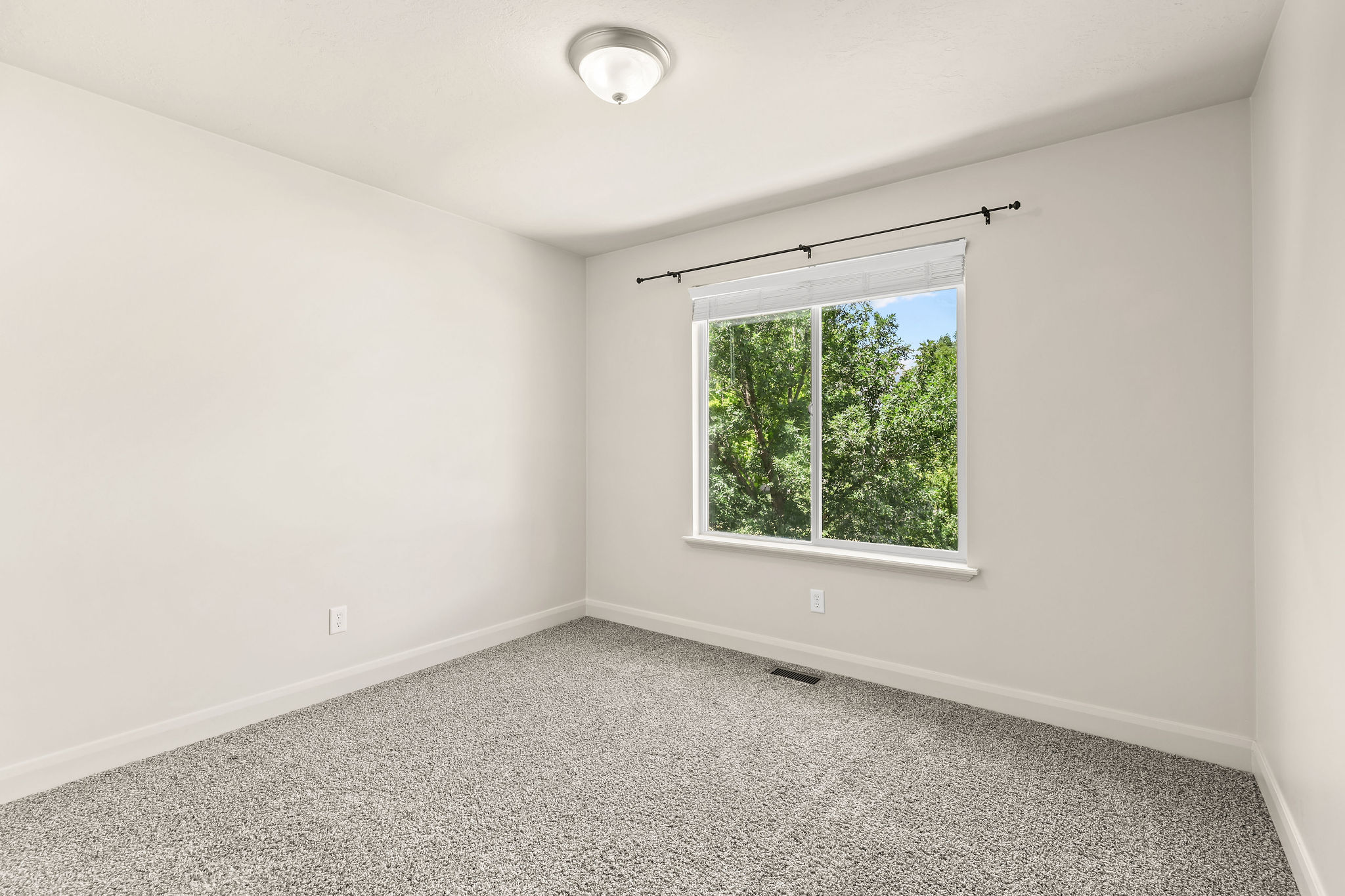 Neutral-toned interior featuring grey carpet flooring and white baseboards