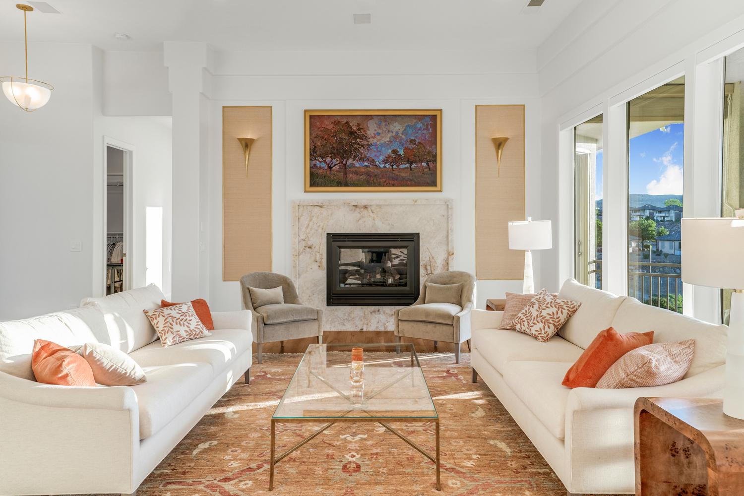 Living area featuring a stone-clad fireplace with a black insert, high ceilings, large sliding glass doors, and recessed lighting