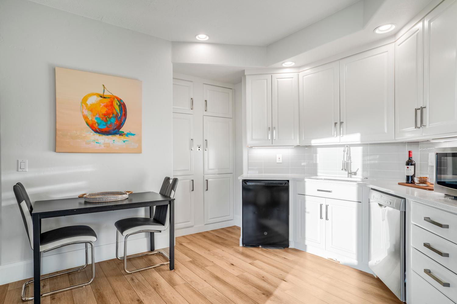 Kitchen featuring white cabinetry, wood-finish flooring, recessed lighting, and a subway tile backsplash
