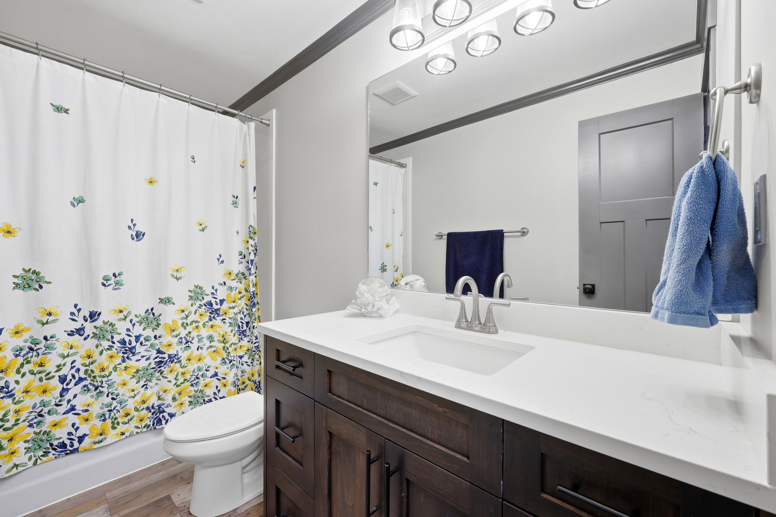 Bathroom featuring a dark wood vanity with a white countertop and an integrated sink