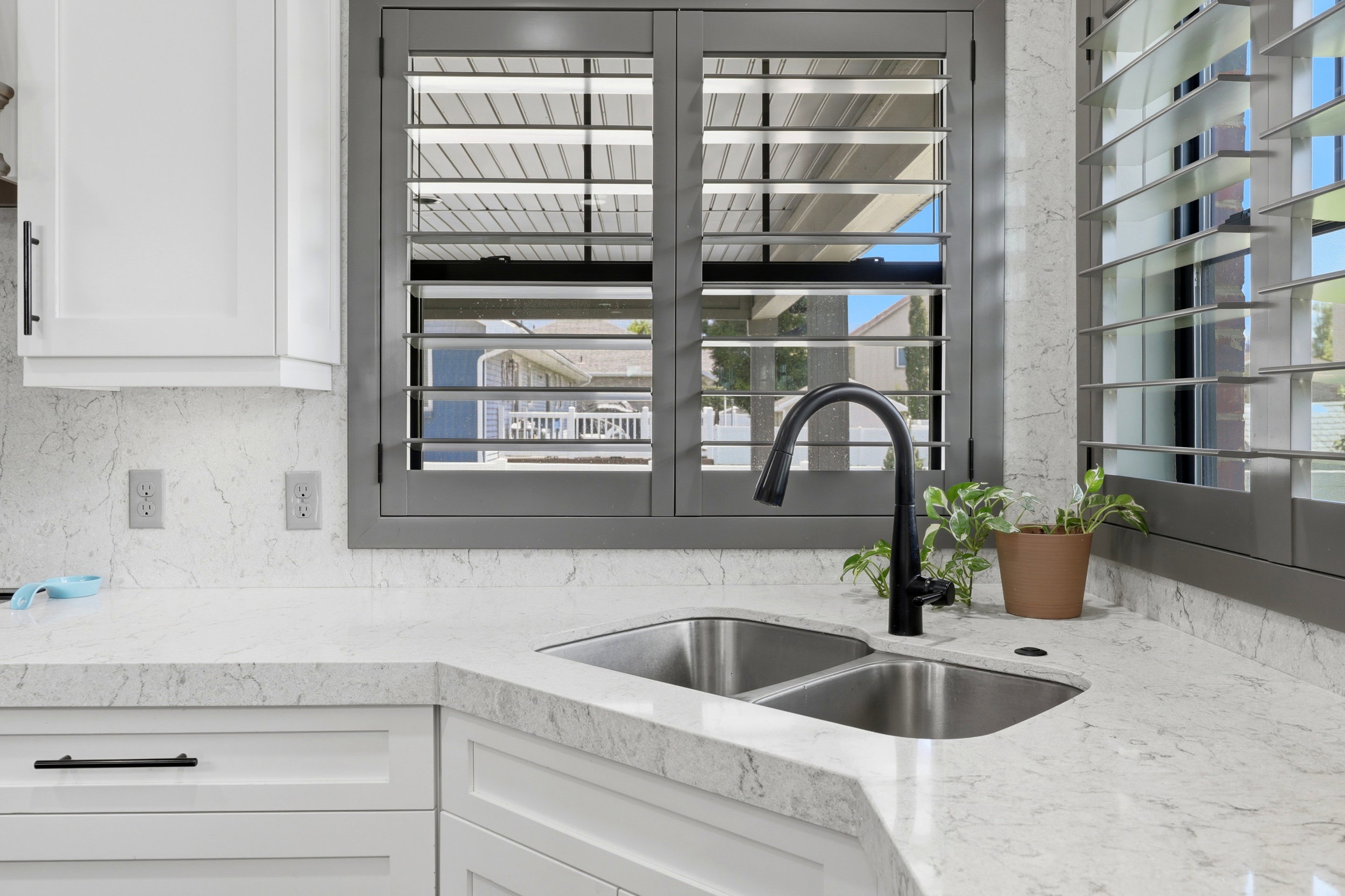 Kitchen sink area featuring light-toned countertops and a double basin stainless steel sink