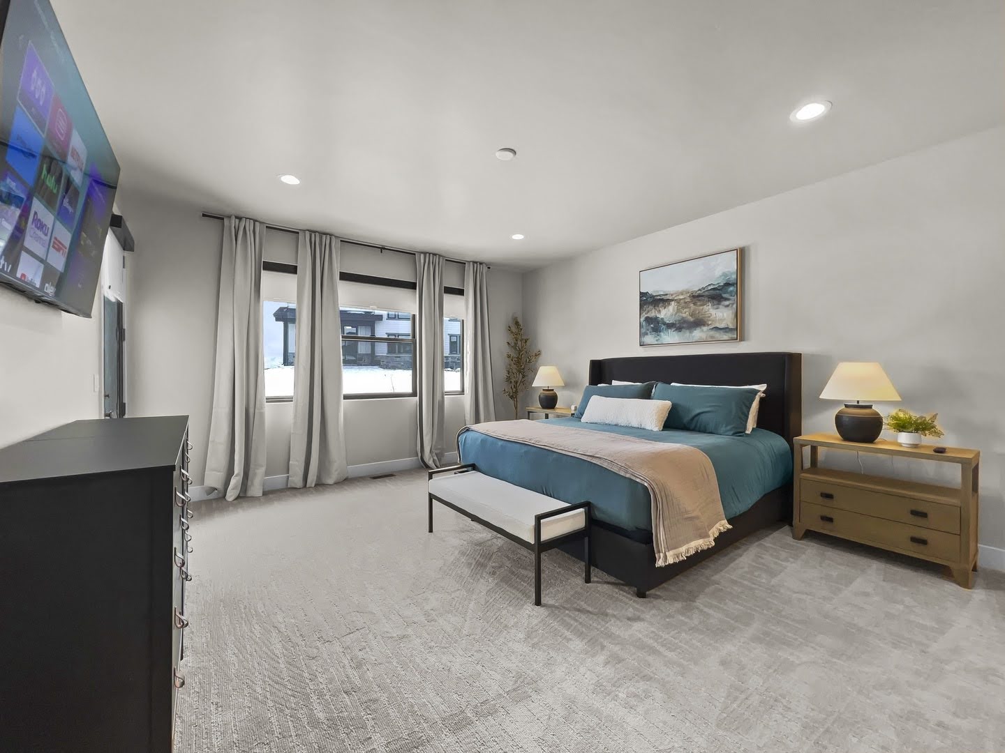 Spacious room featuring light-colored walls and patterned carpeting