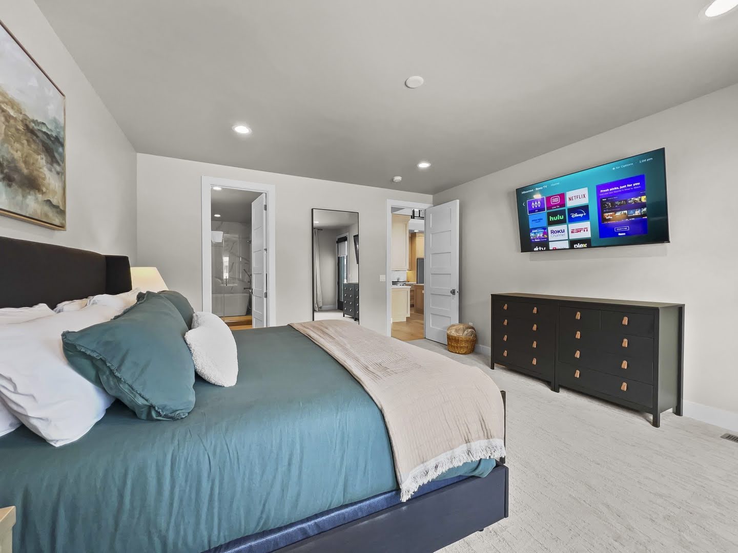 Spacious bedroom with light-colored carpeting and recessed lighting