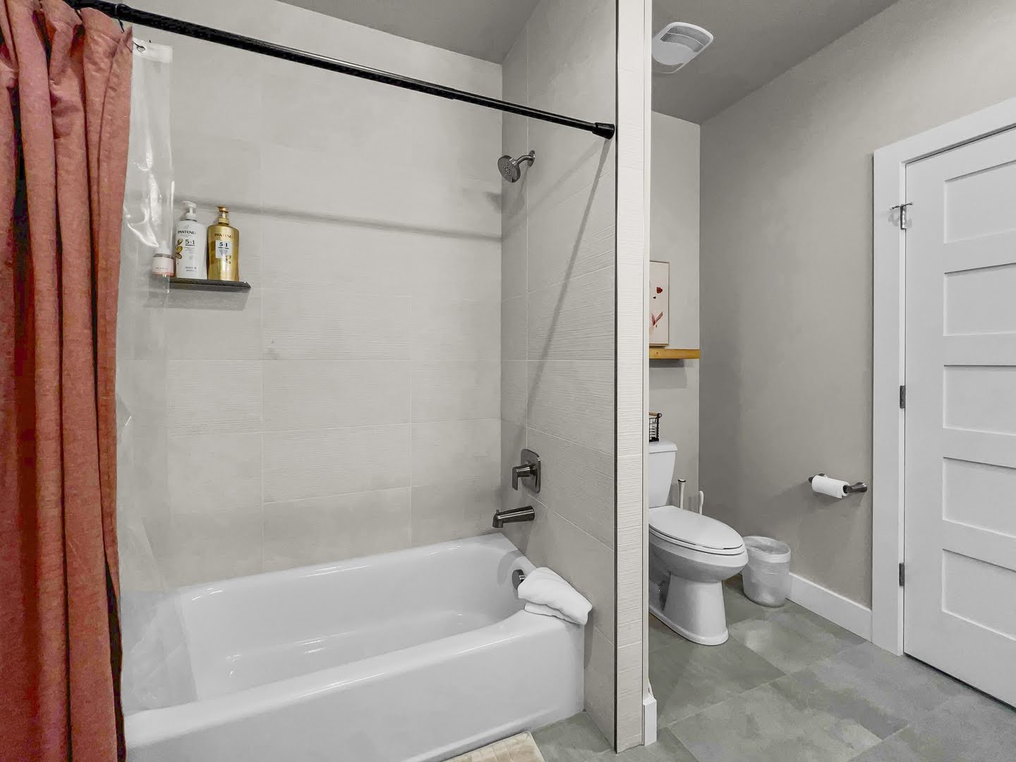 Bathroom featuring a tub and shower combination with light-toned tiled walls