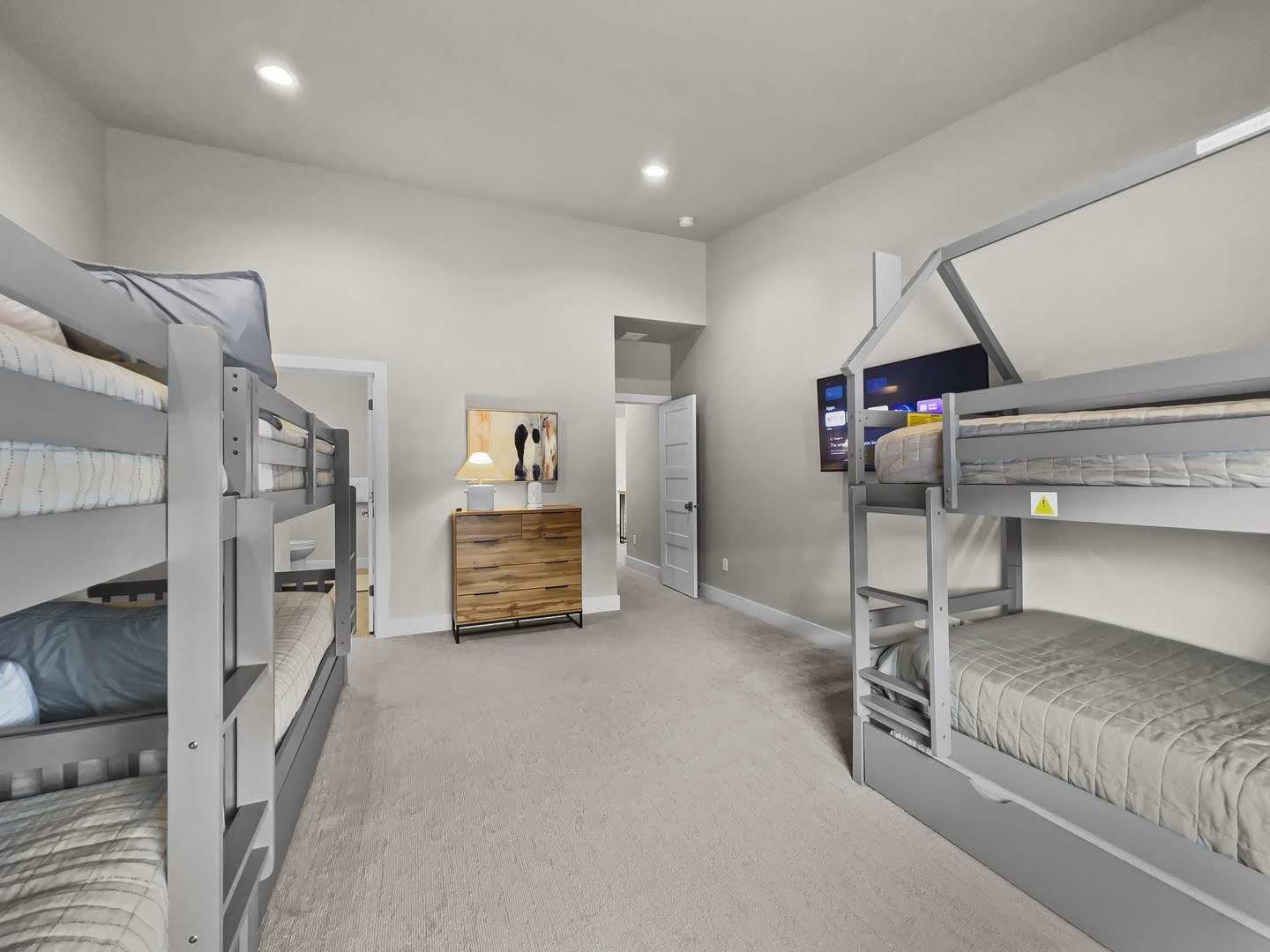 Carpeted room featuring multiple bunk beds, recessed lighting, and a wood-finish chest of drawers