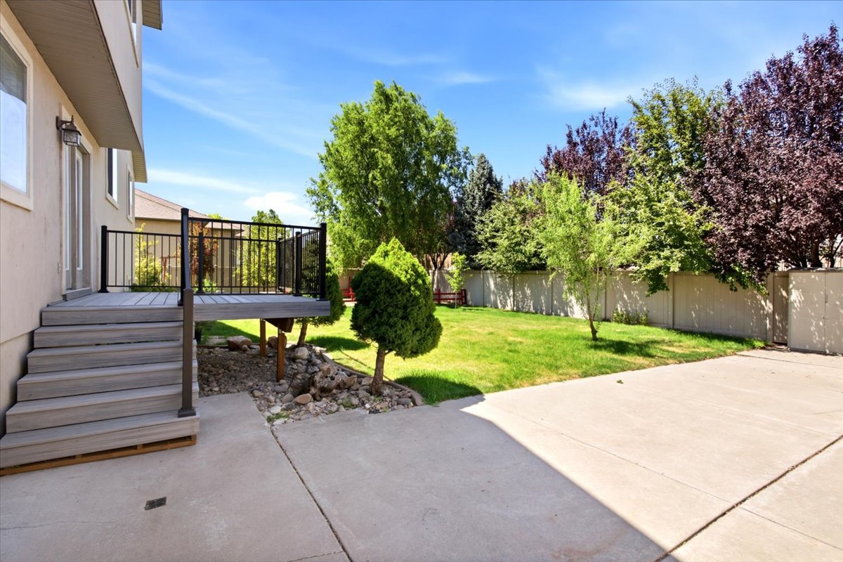 Rear exterior featuring a multi-level deck with black railings and steps