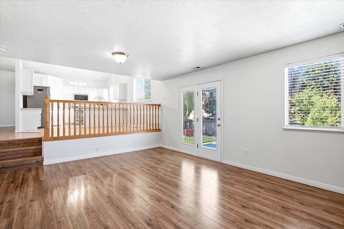 Wood-finish flooring throughout, featuring a white painted railing with wood balusters and top rail
