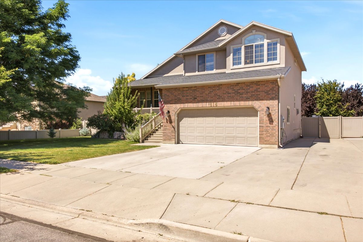 Two-story residence featuring a brick and stucco exterior, an arched window on the upper level, and a two-car garage