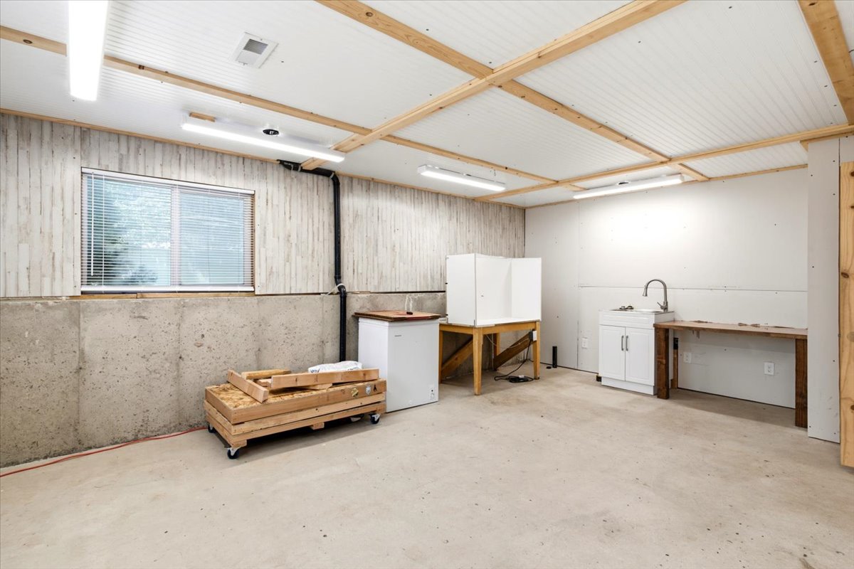 Utility room featuring concrete flooring and a window with blinds