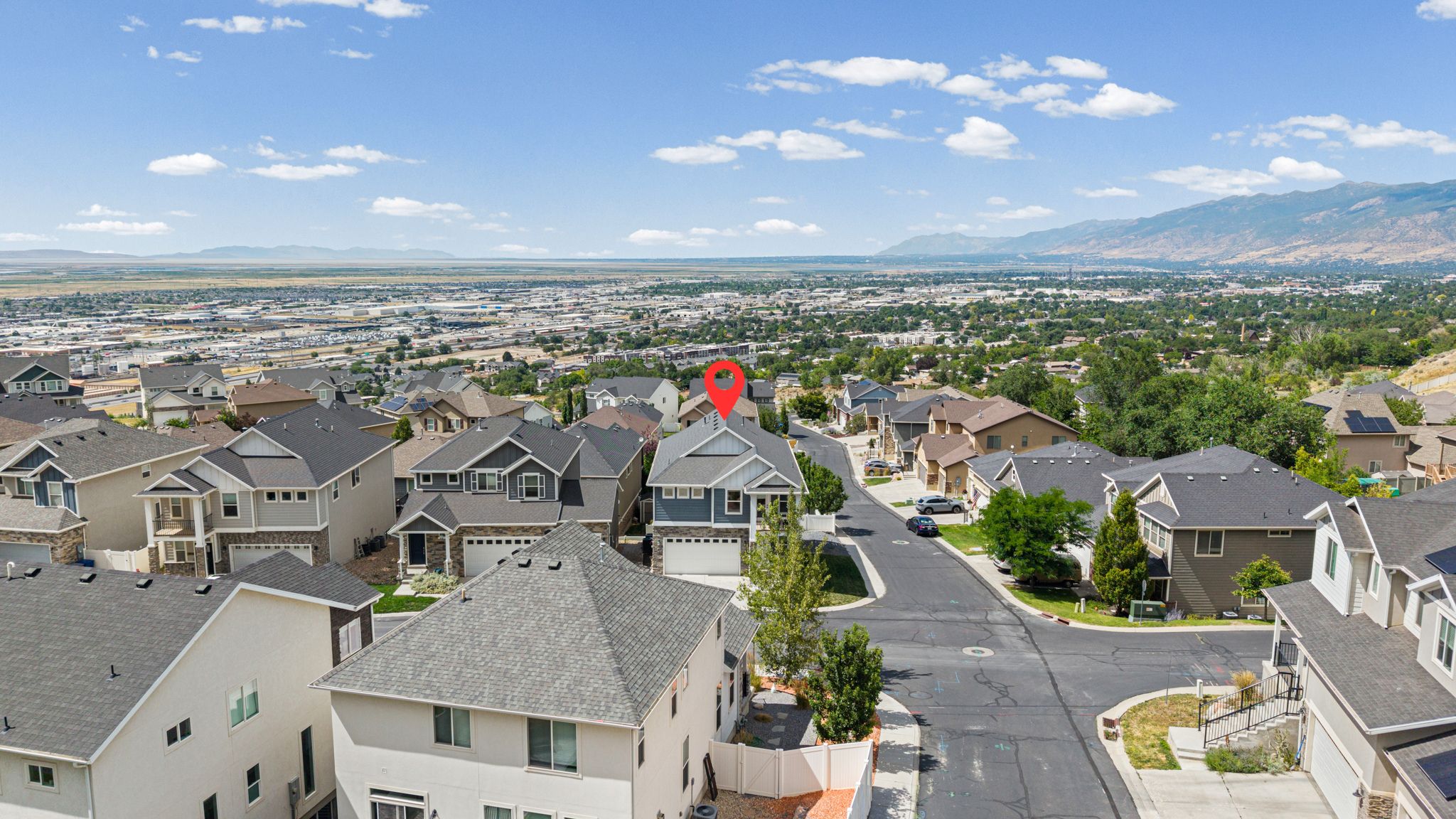 Aerial perspective showcasing a residential neighborhood with surrounding mountains and expansive urban landscape