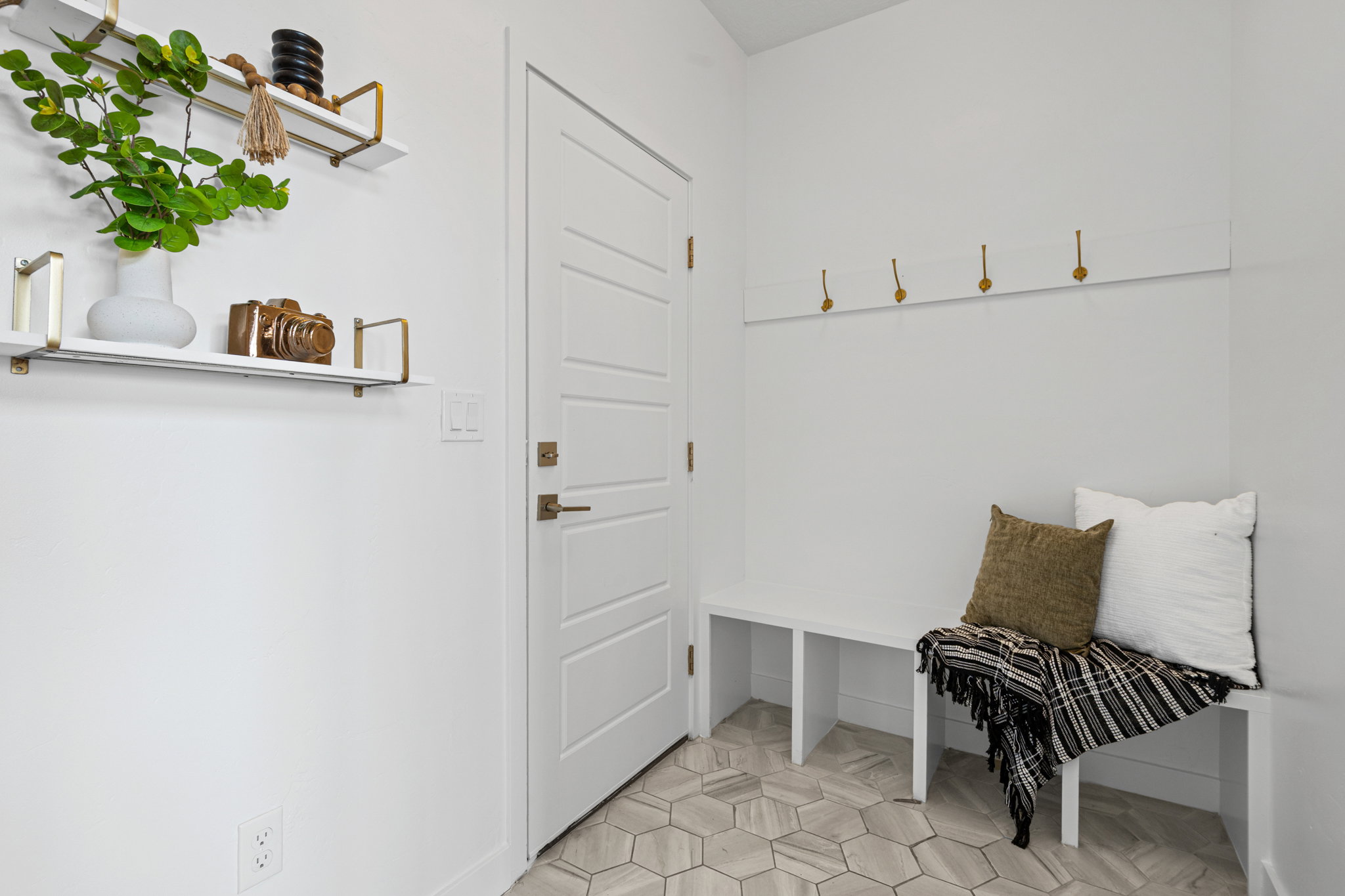 Entryway featuring a built-in bench, hexagonal tile flooring, and integrated wall hooks