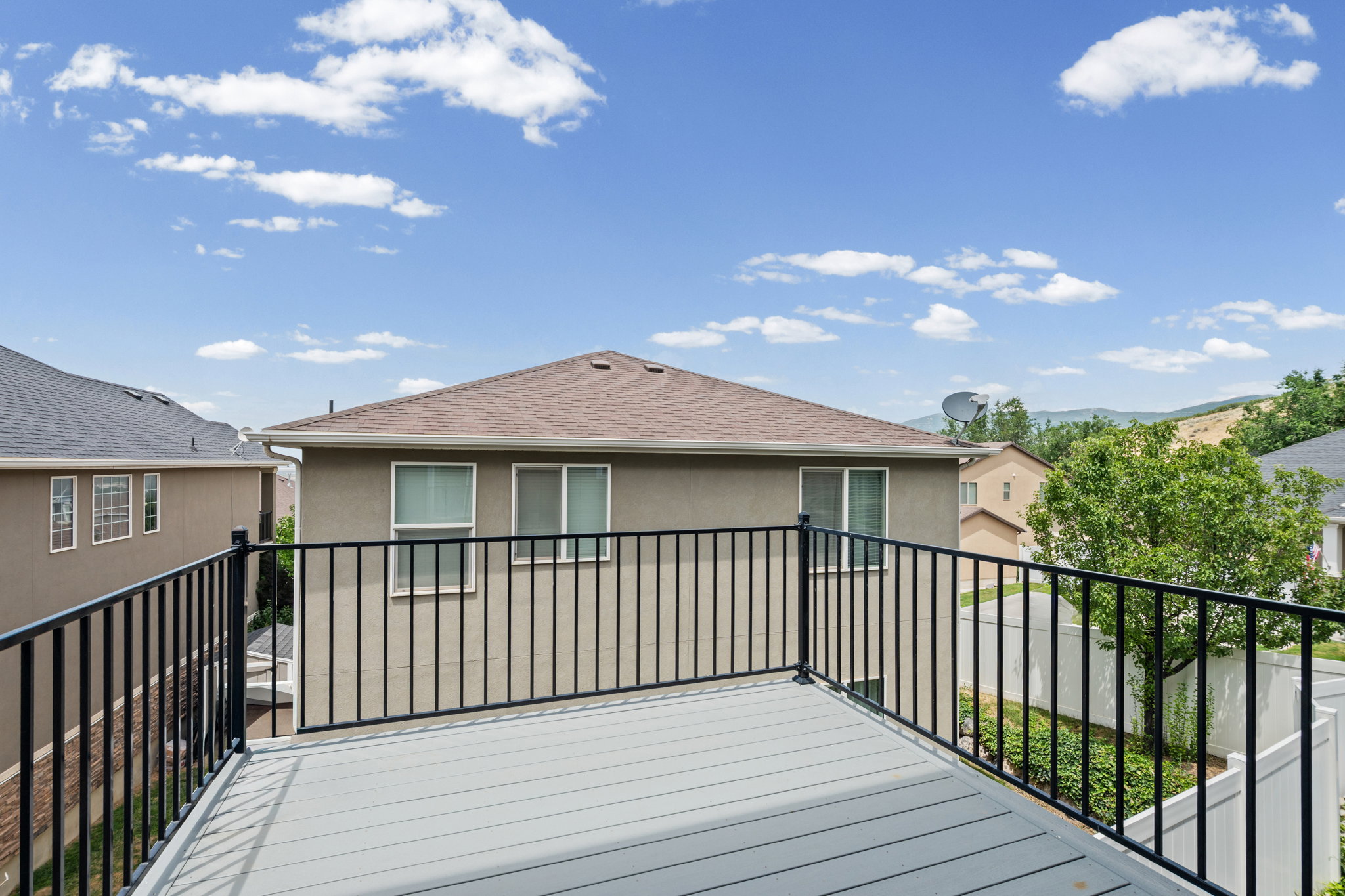 Outdoor deck featuring composite flooring and black metal railings