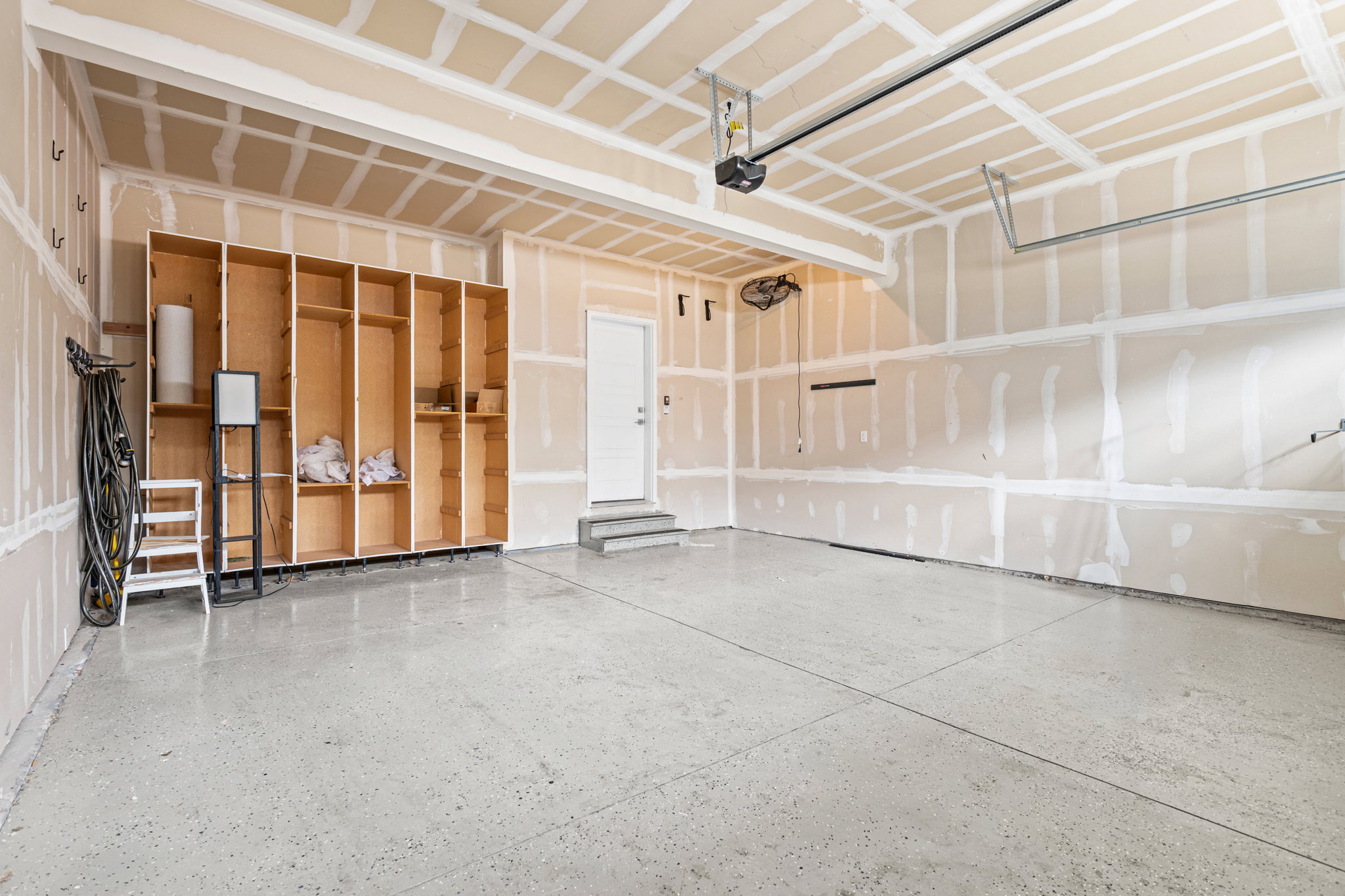 Spacious garage with an epoxy-coated concrete floor and built-in wood shelving units
