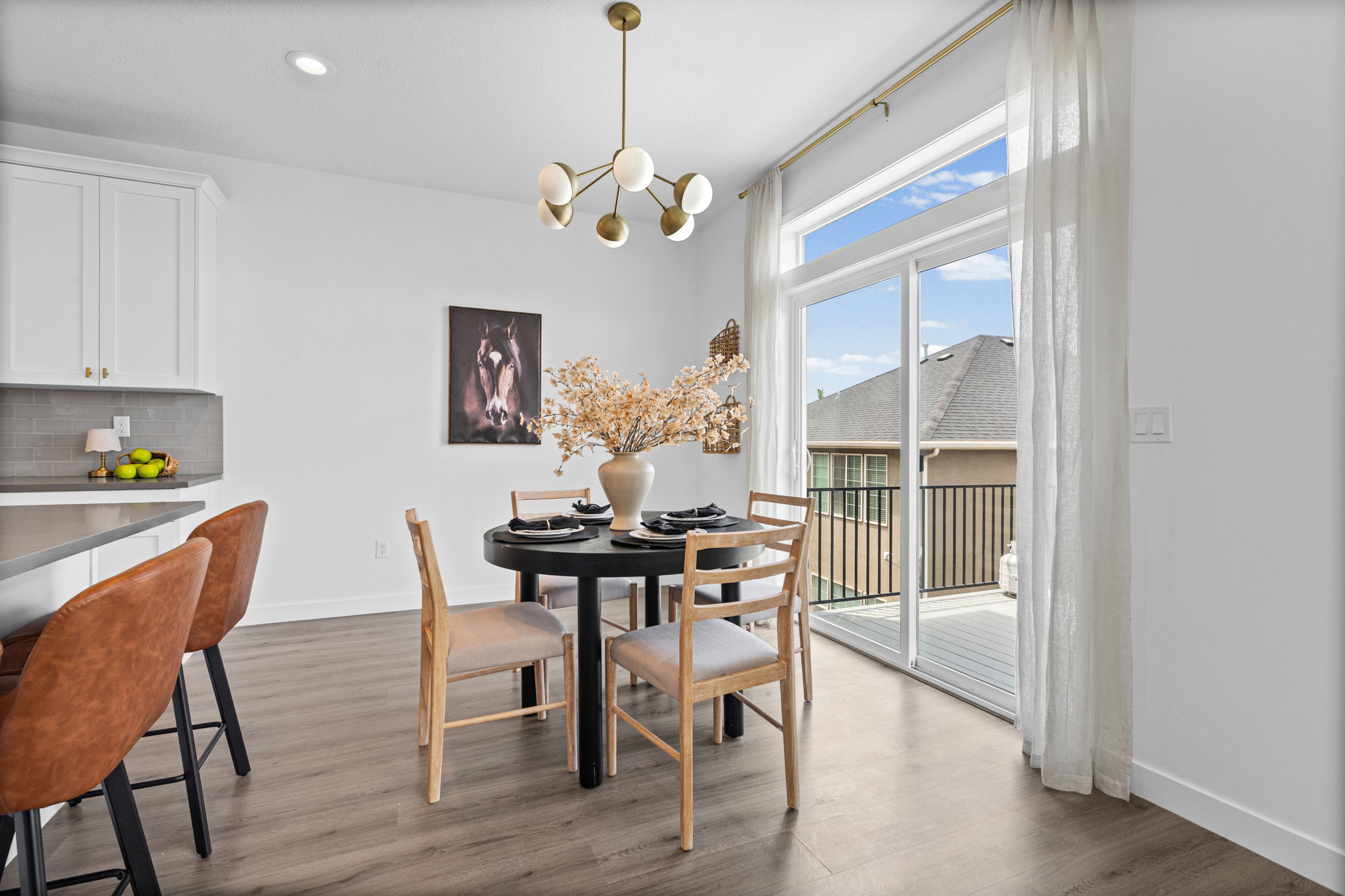 Dining area featuring a modern brass chandelier and wood-finish flooring