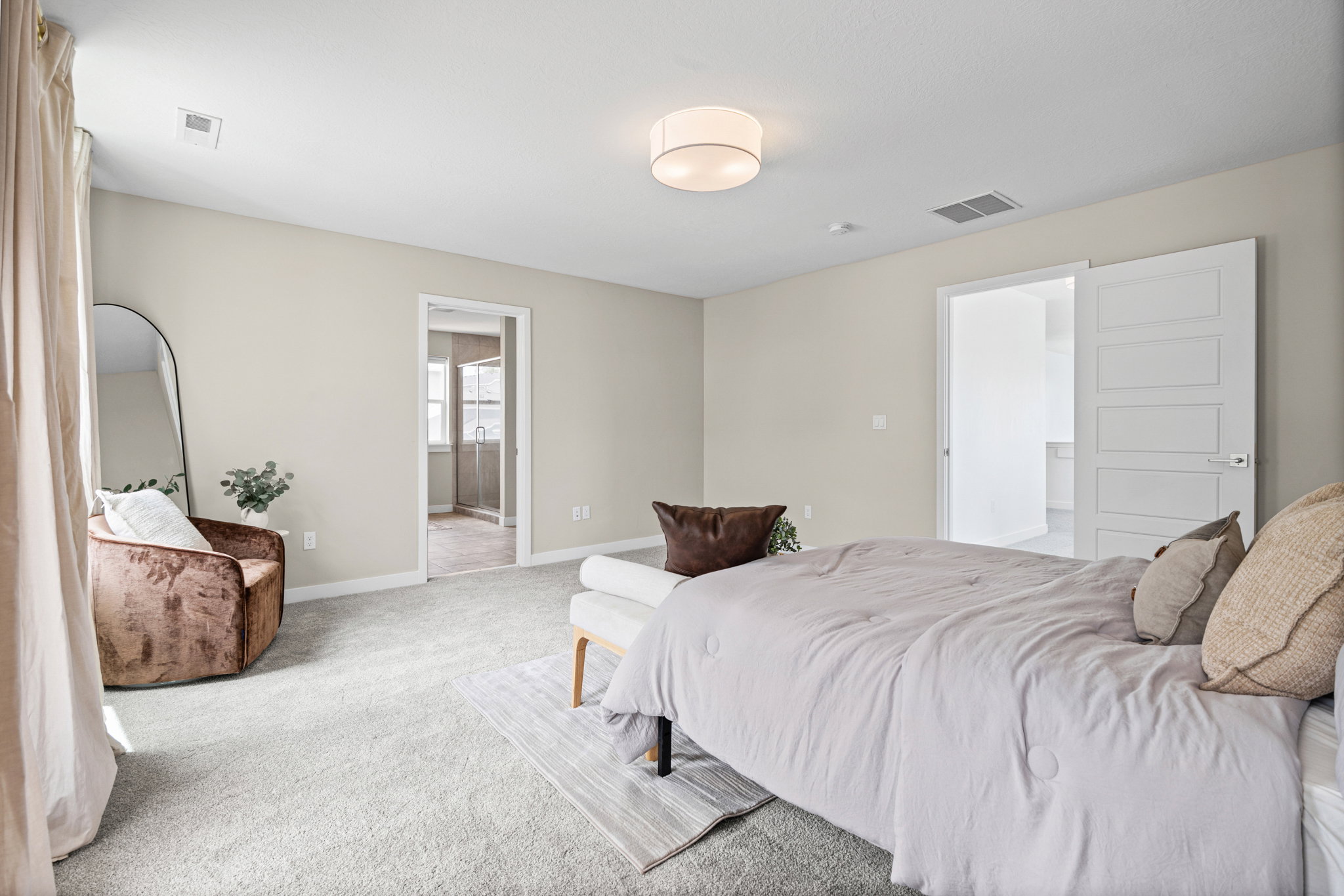 Expansive carpeted room featuring neutral wall tones, a contemporary ceiling light fixture, and white trim