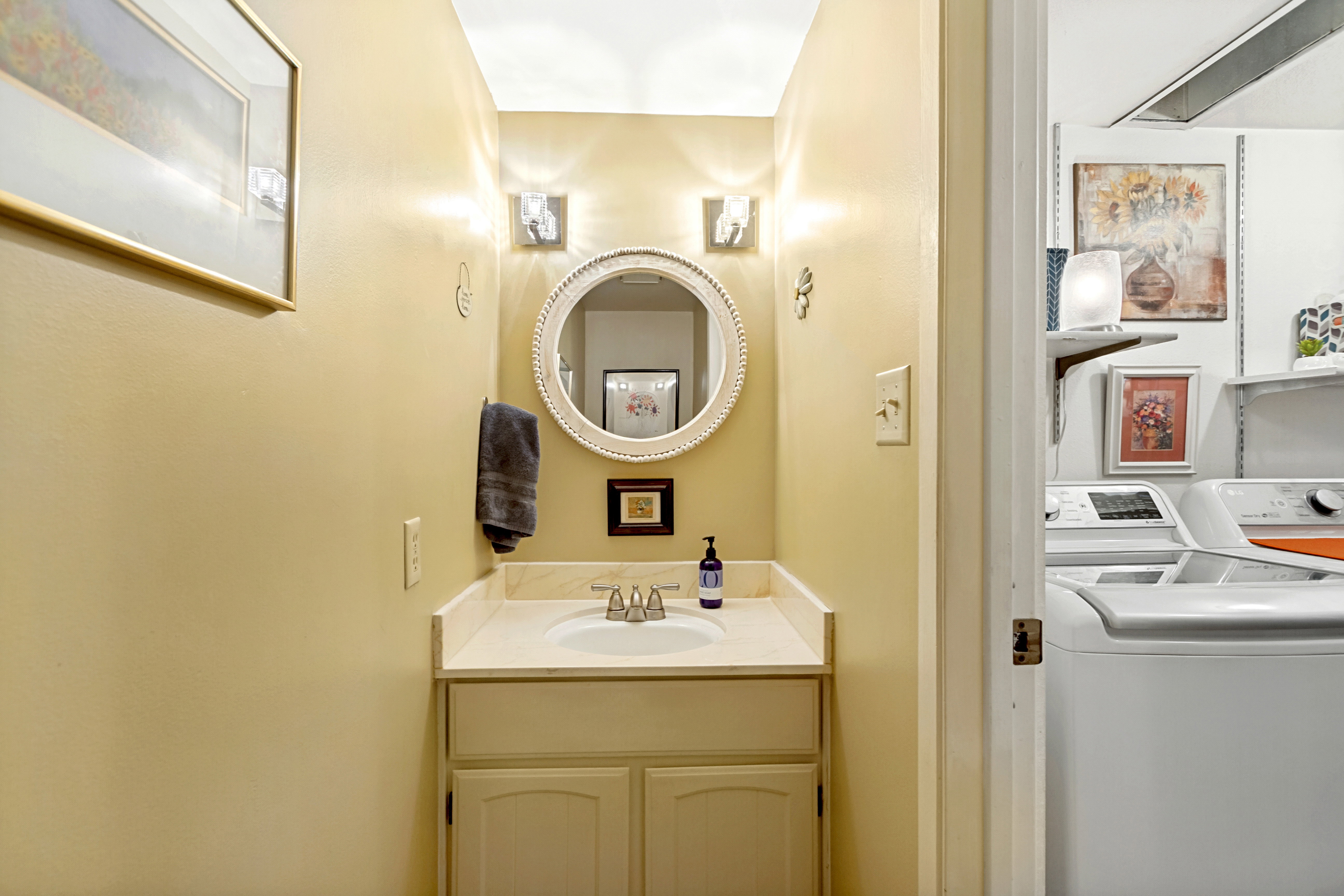 Bathroom vanity featuring a single basin sink, light-toned countertop, and under-sink cabinetry