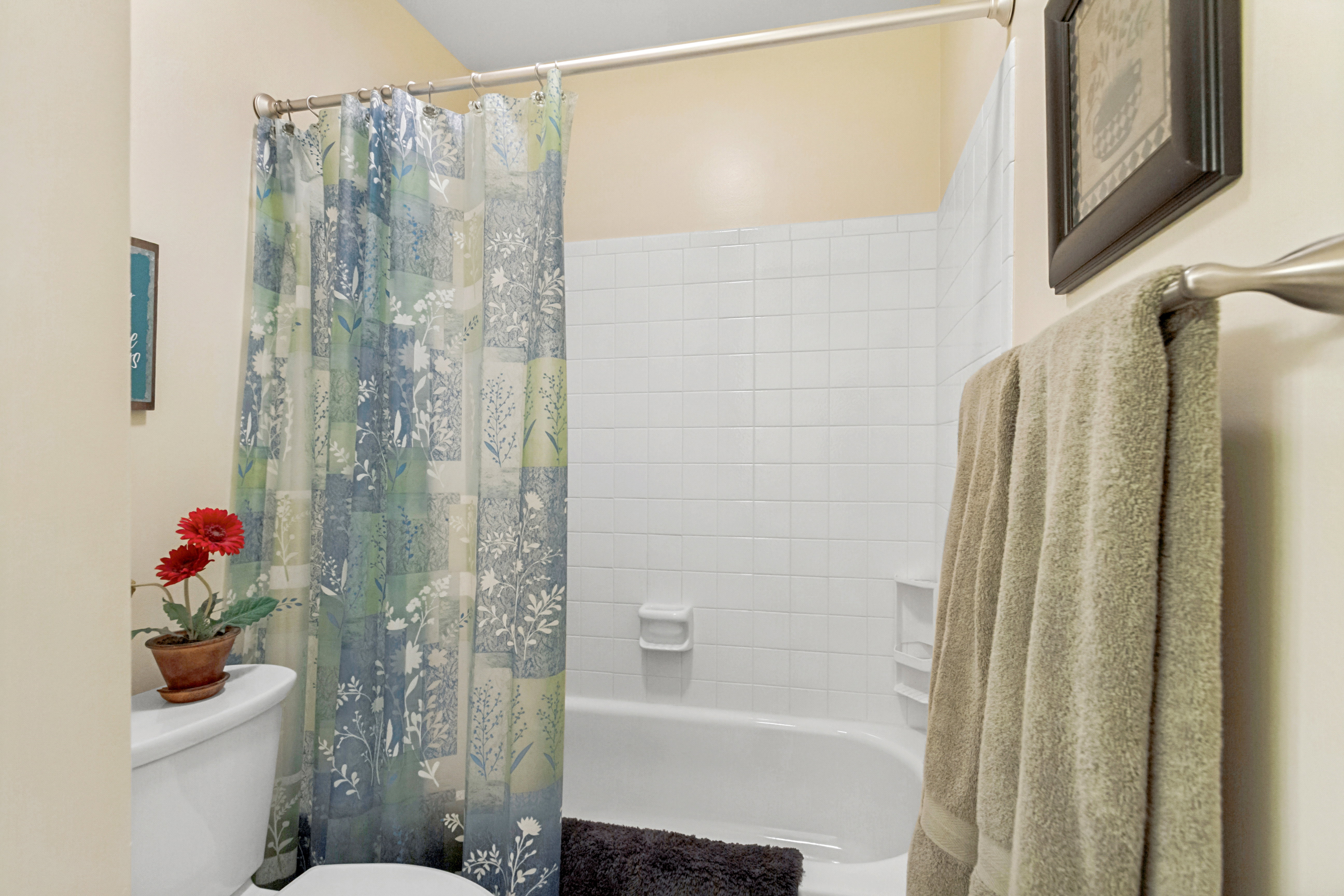 Bathroom featuring a white bathtub, white subway tile surround, and a brushed nickel towel bar