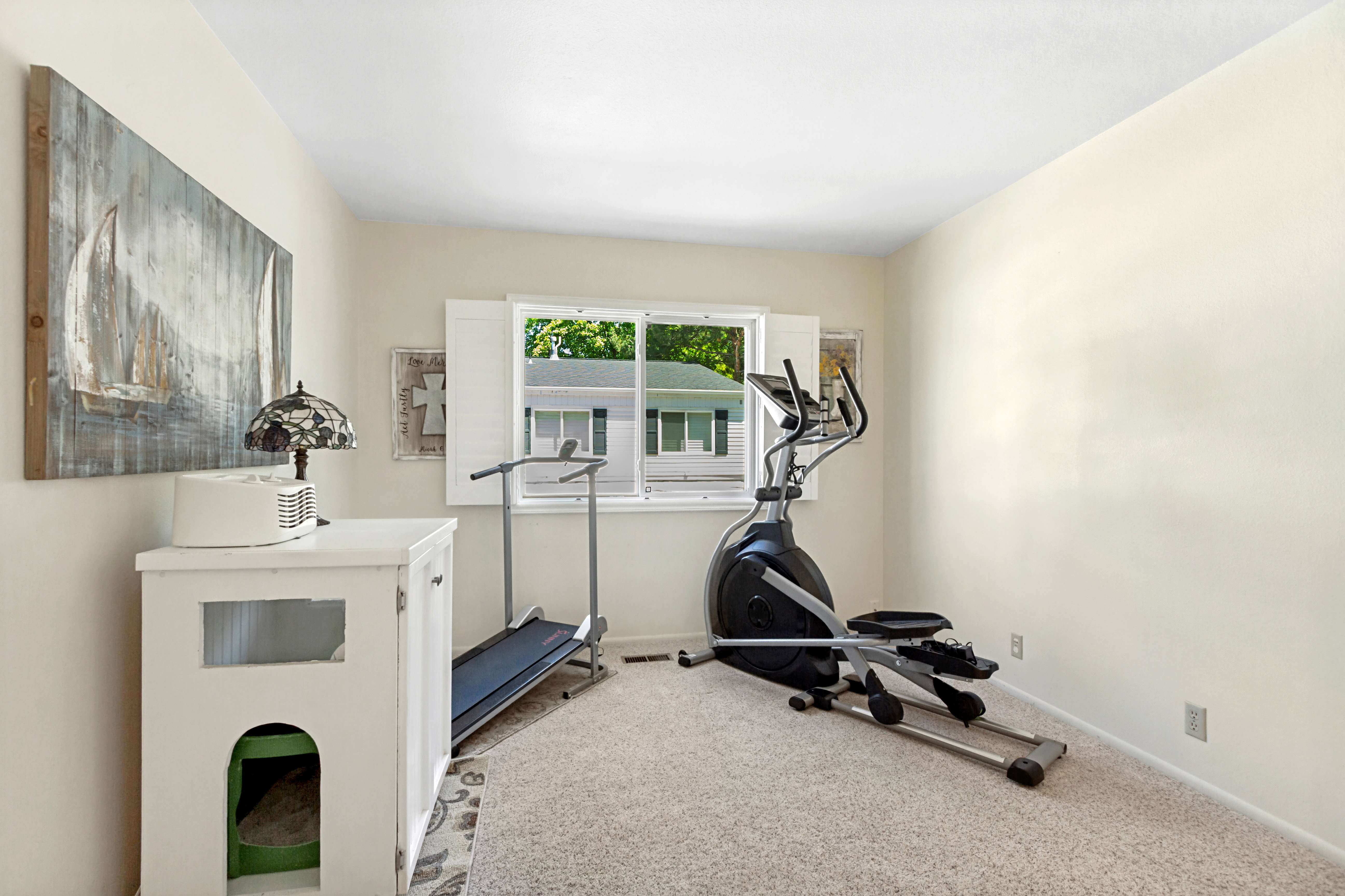 Carpeted room with a double window and white shutters