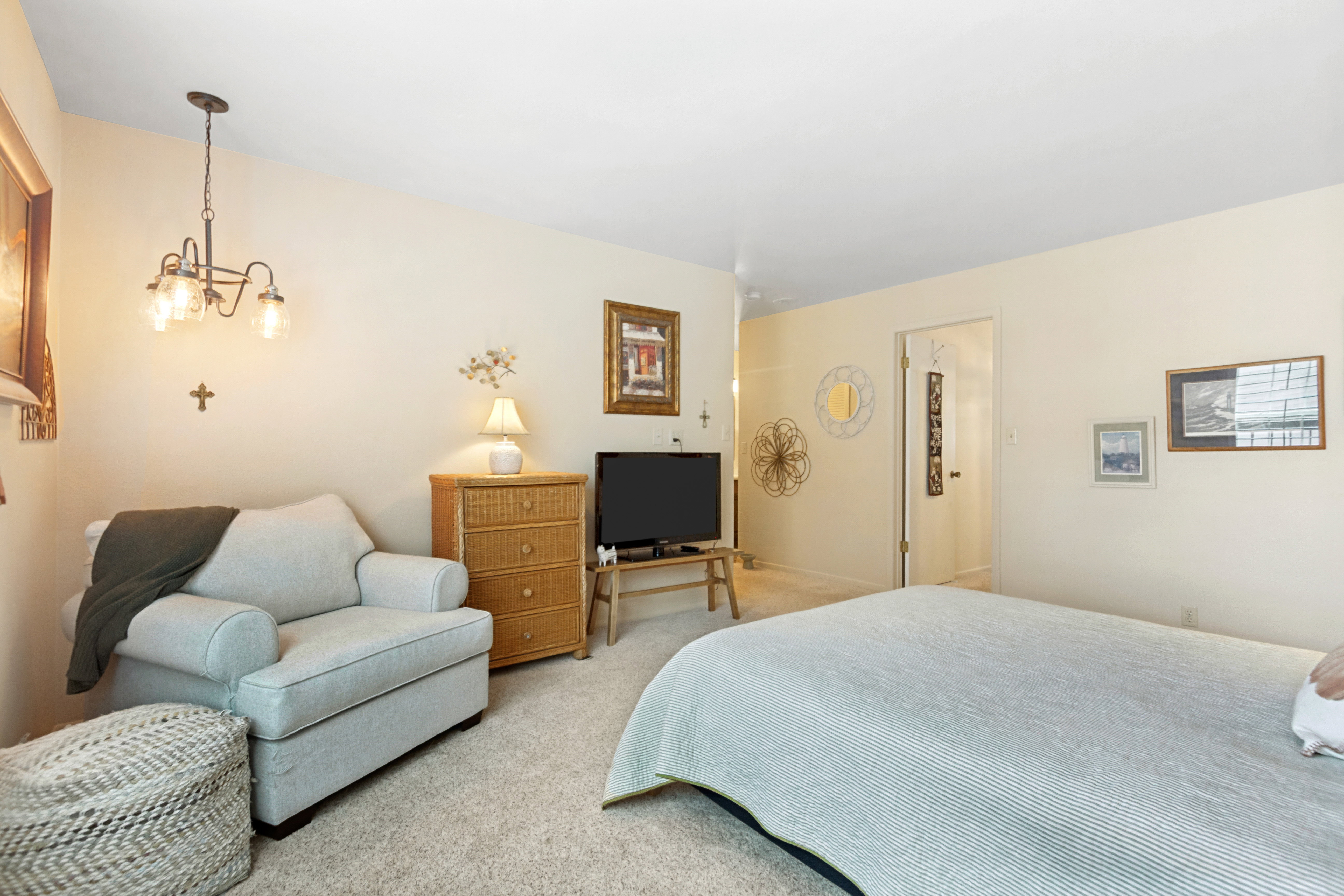 Carpeted bedroom featuring neutral wall tones, a ceiling-mounted light fixture, and a solid core door