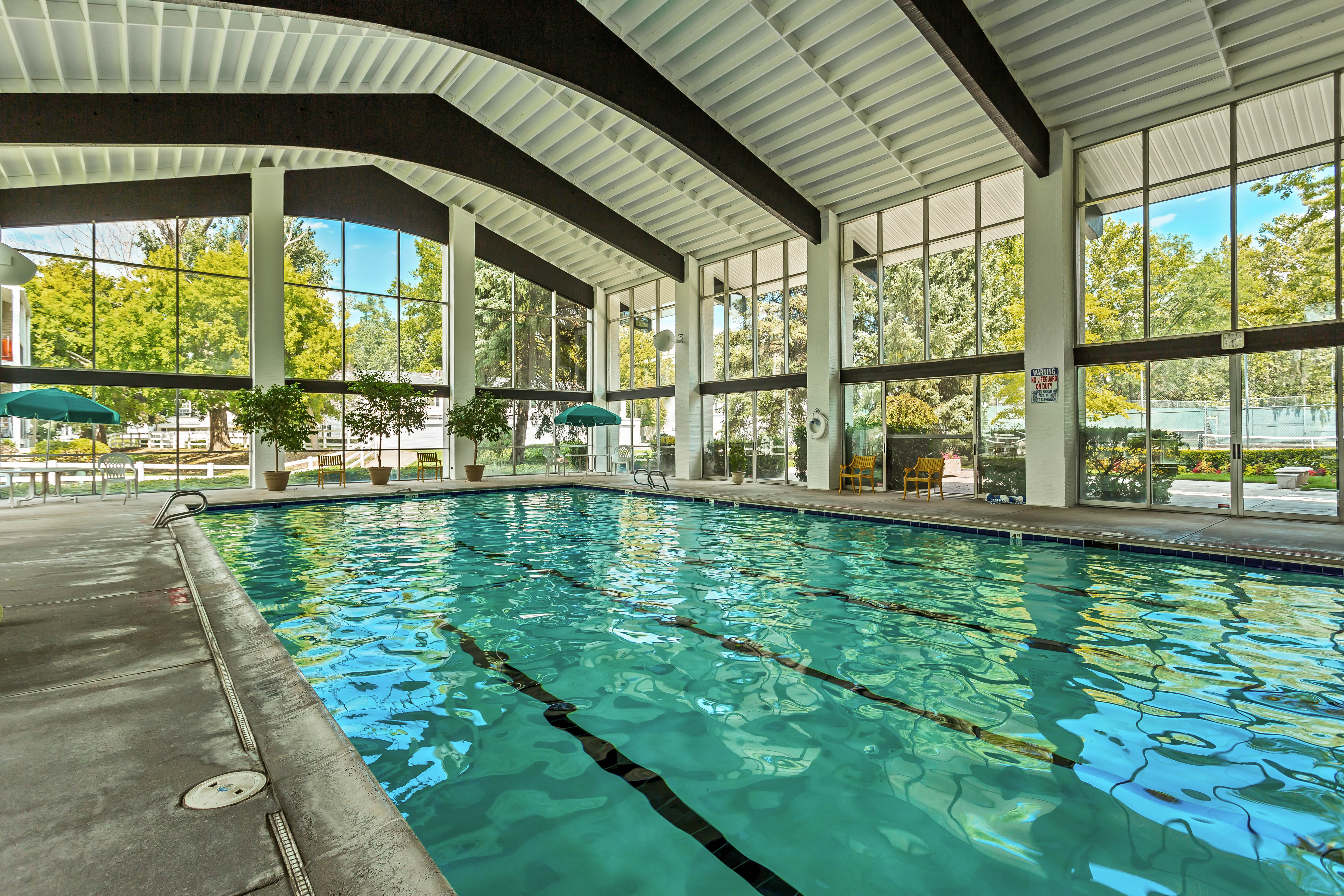 Indoor swimming pool featuring multiple lanes and surrounding concrete decking