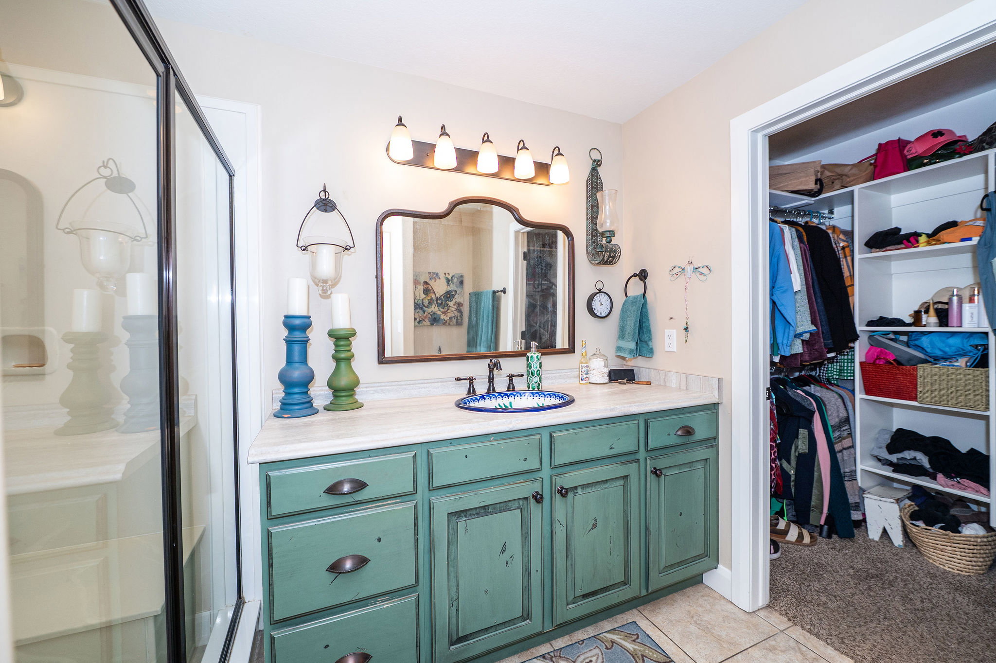 Bathroom vanity featuring a light-colored countertop, a single basin sink, and a distressed green cabinet with multiple drawers and doors