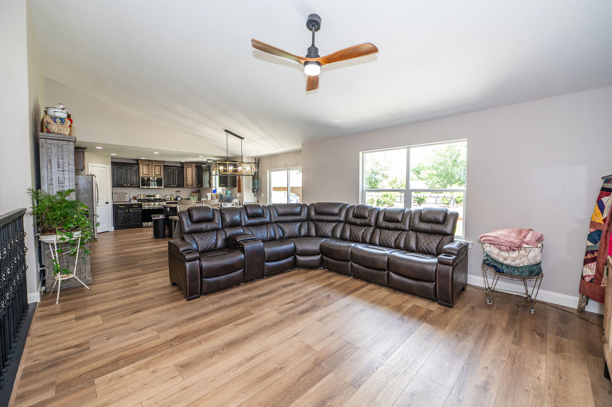 Open-concept living space with wood-finish flooring extending into the kitchen