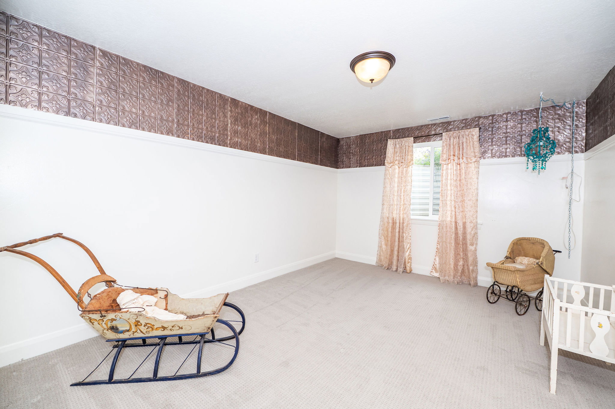 Spacious room featuring white walls, textured brown wall covering, and light neutral carpeting