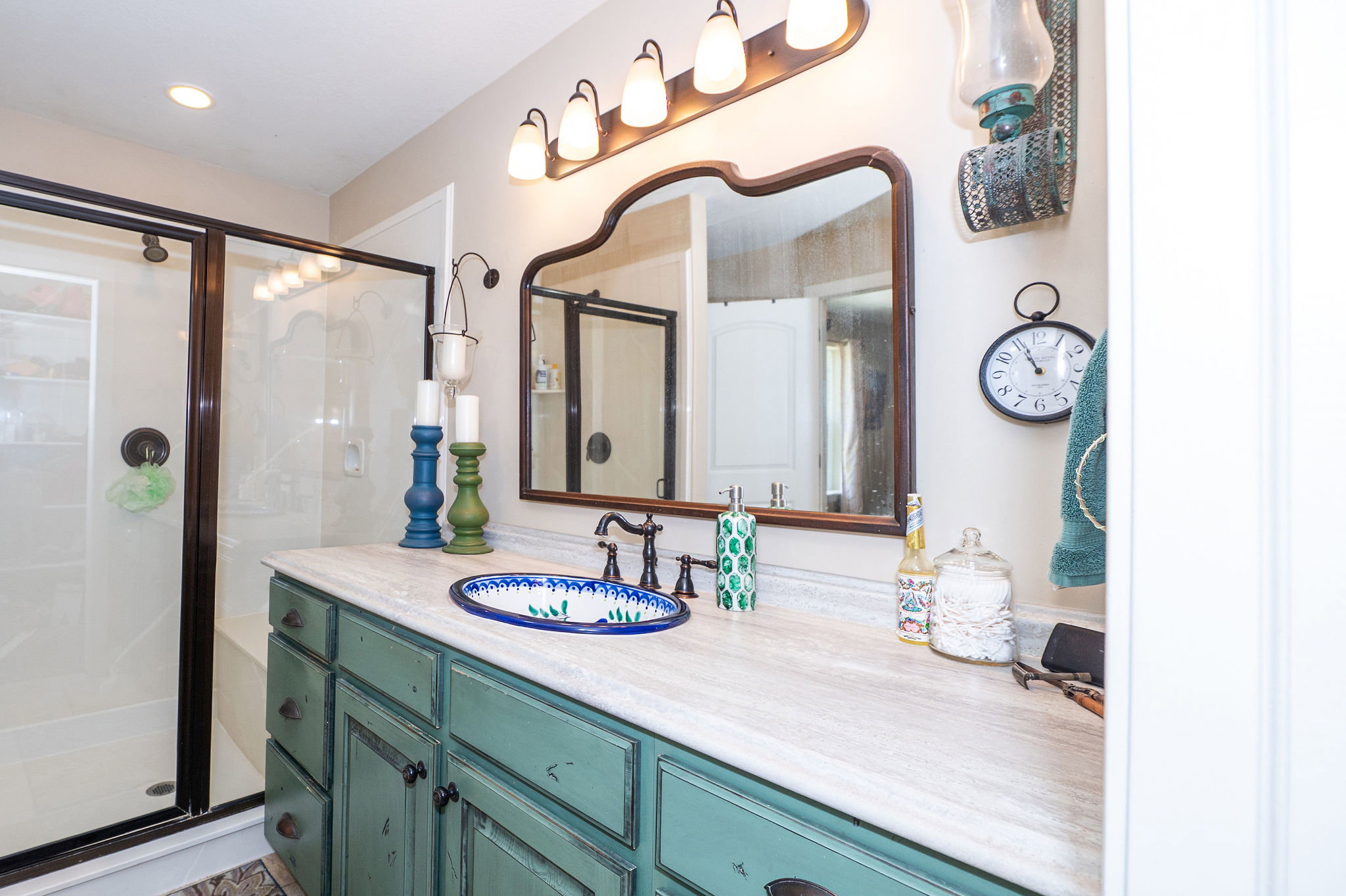 Bathroom featuring a distressed green vanity with an integrated sink, a light-toned countertop, and a dark bronze faucet