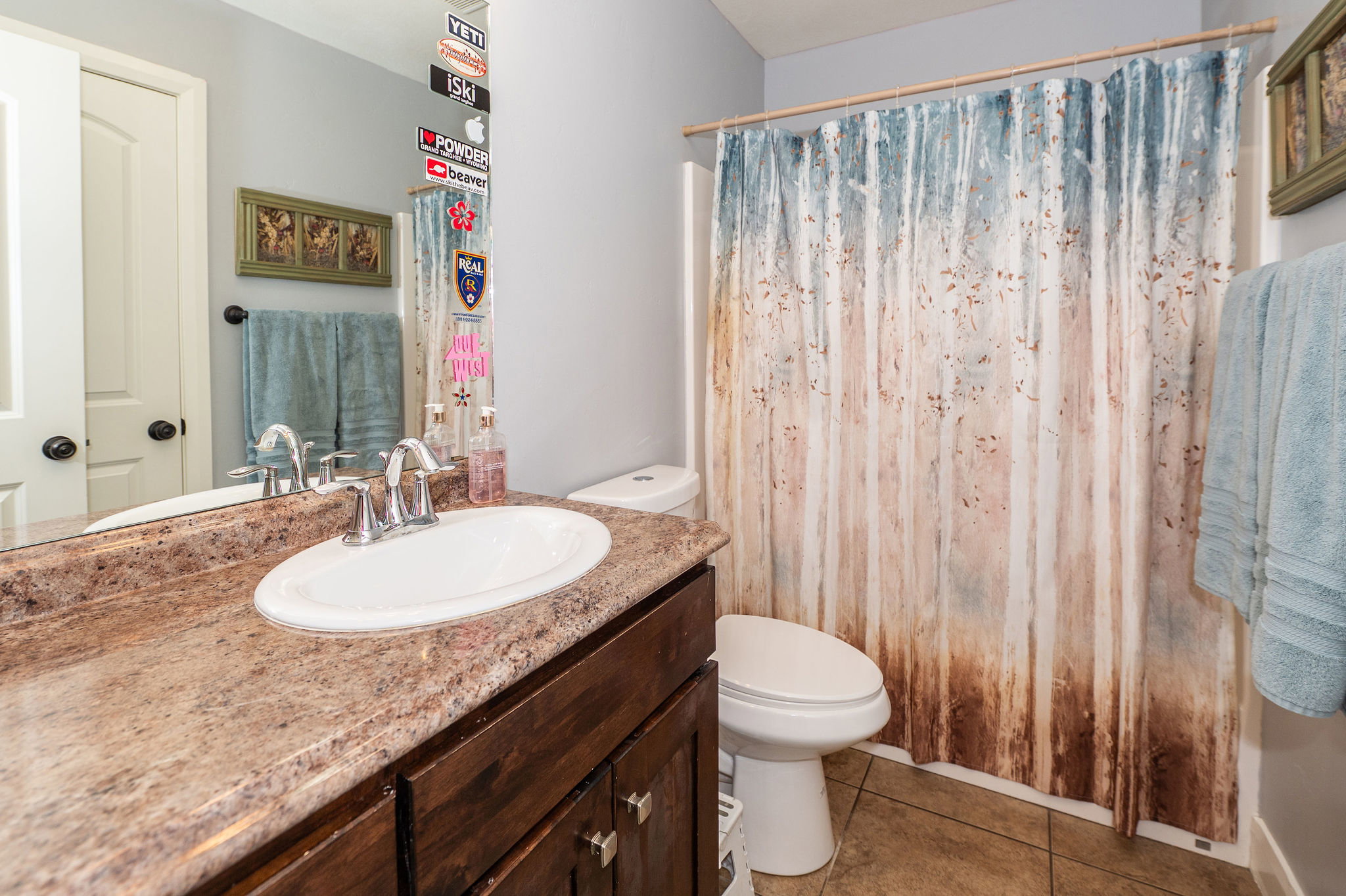 Bathroom featuring a vanity with an oval sink, chrome faucet, and stone-finish countertop