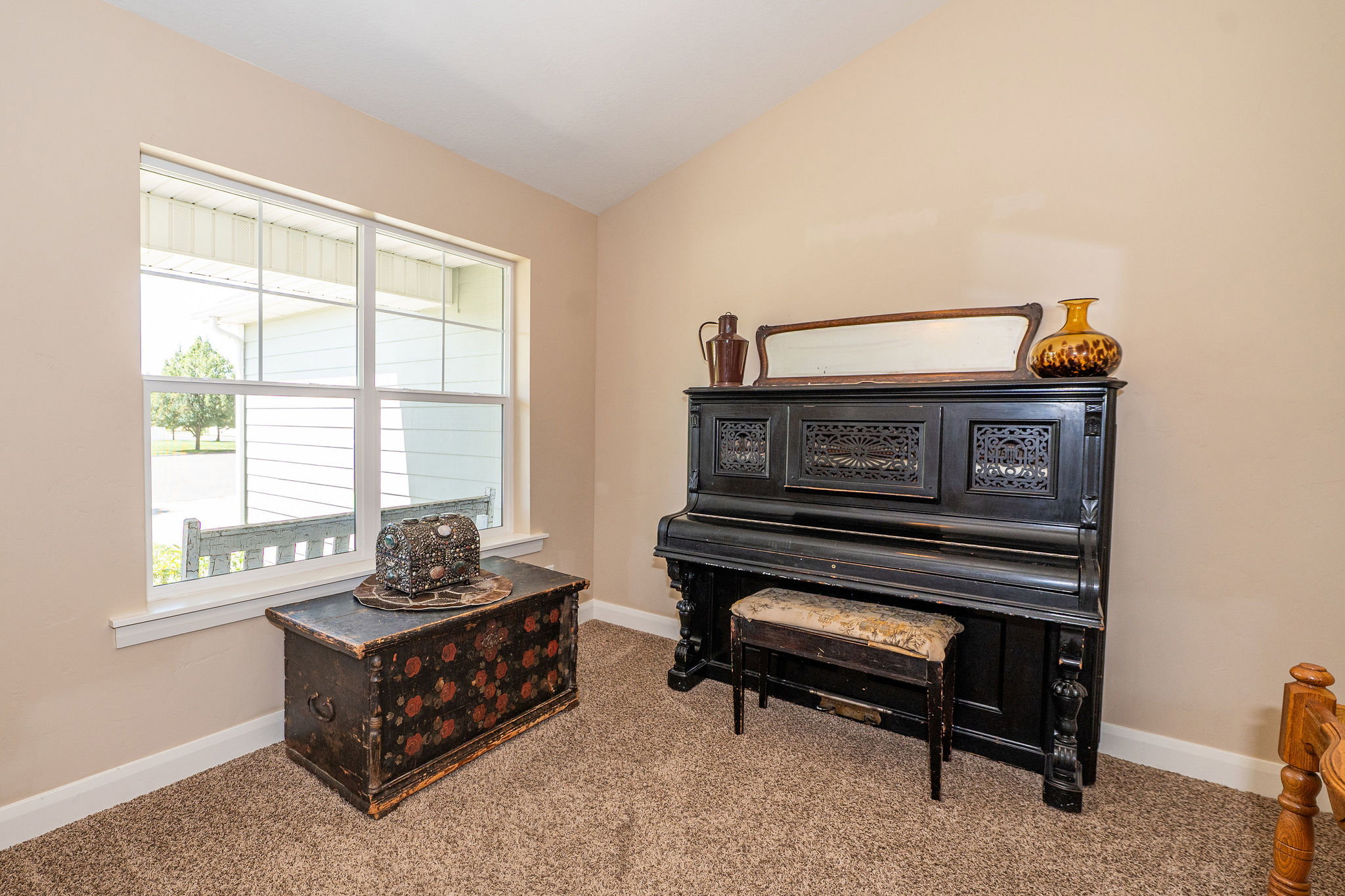 Carpeted interior room with neutral-toned walls and a vaulted ceiling
