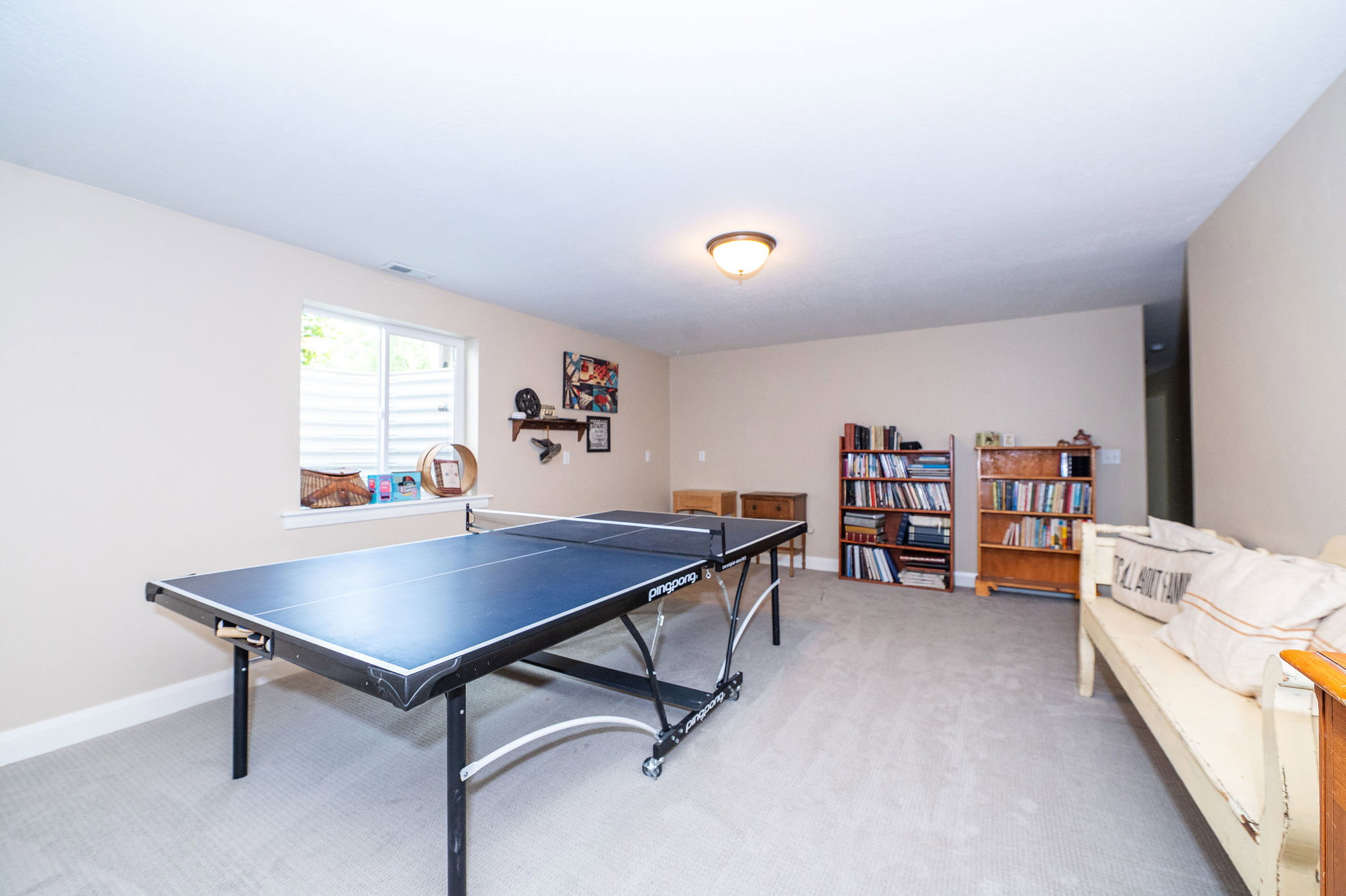 Spacious lower-level room featuring light-toned carpeting and neutral wall tones