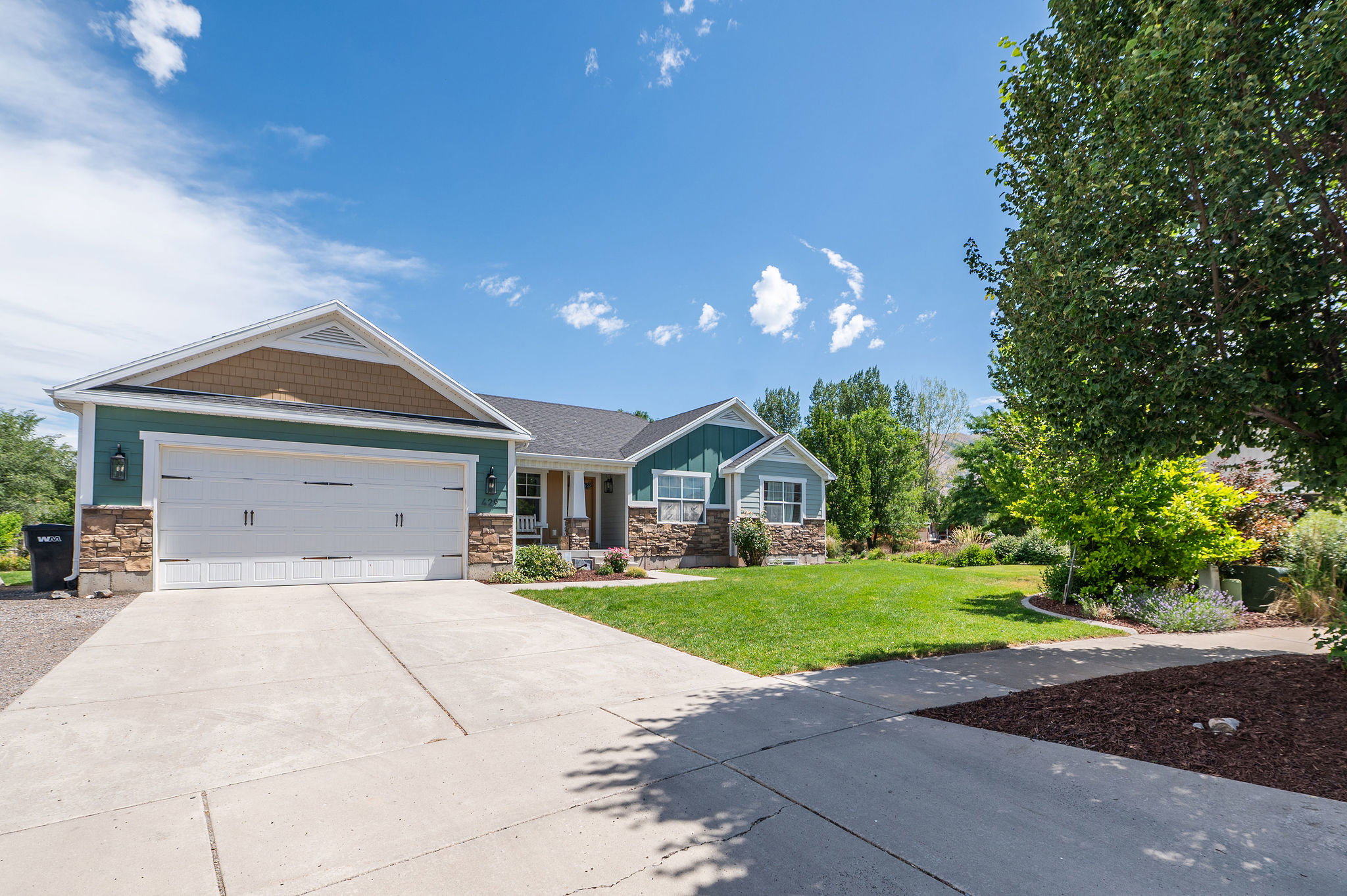 Ranch-style exterior with teal siding and stone veneer accents