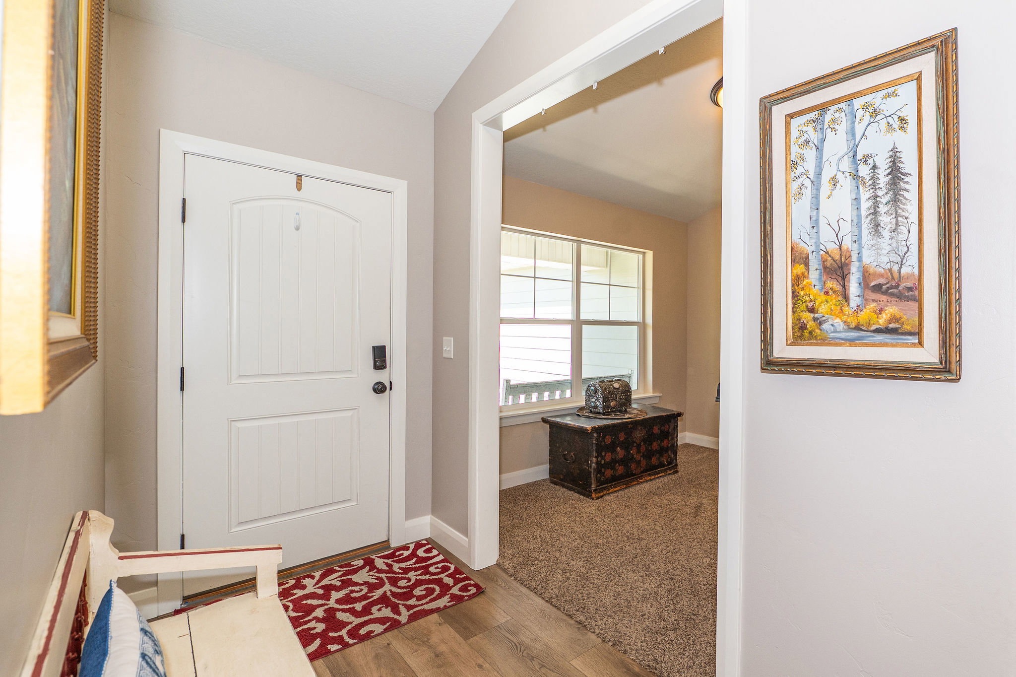 Entryway featuring wood-finish flooring, a white paneled door with dark hardware, and neutral wall paint