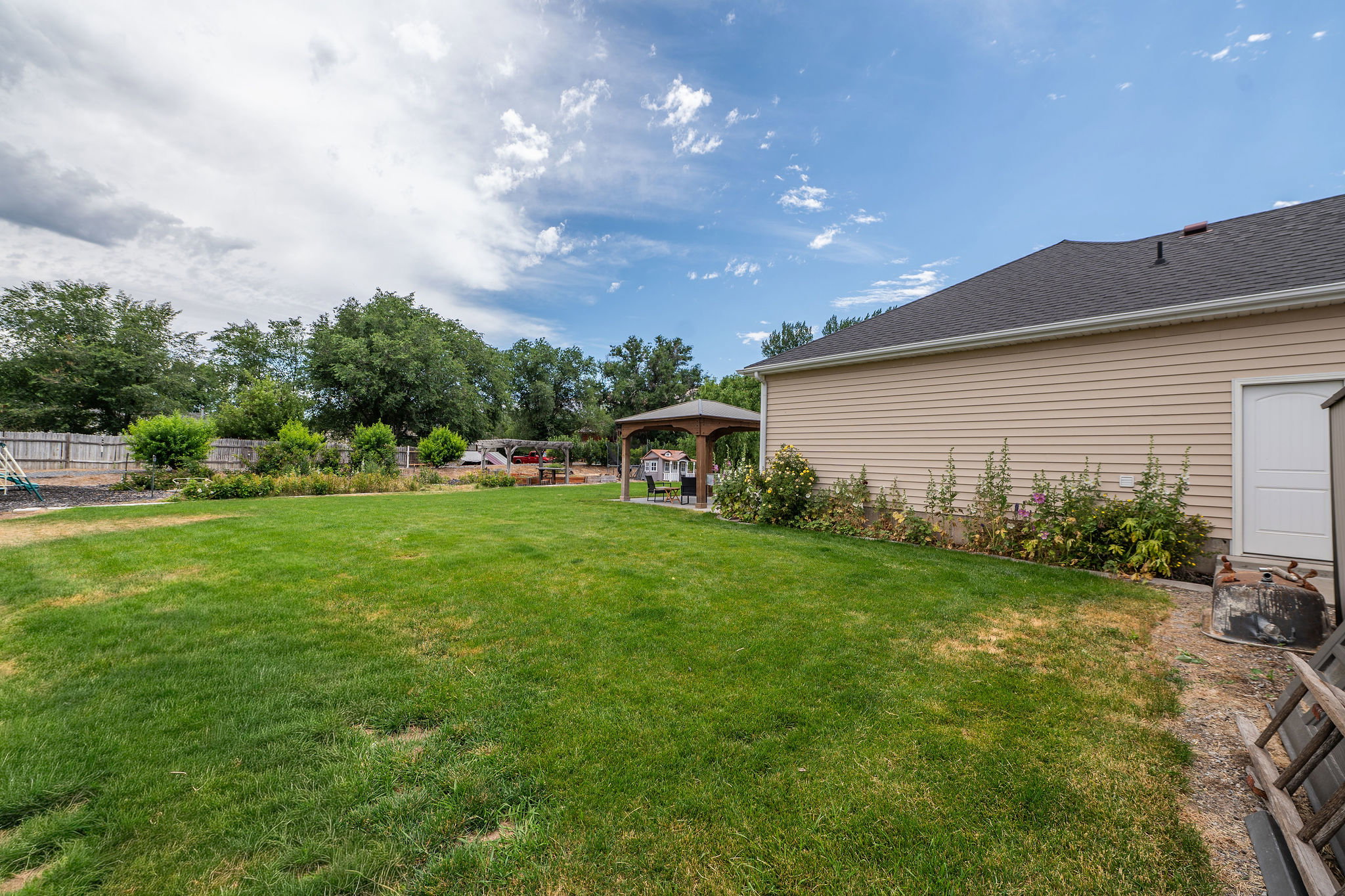 Expansive green lawn with a wood fence perimeter