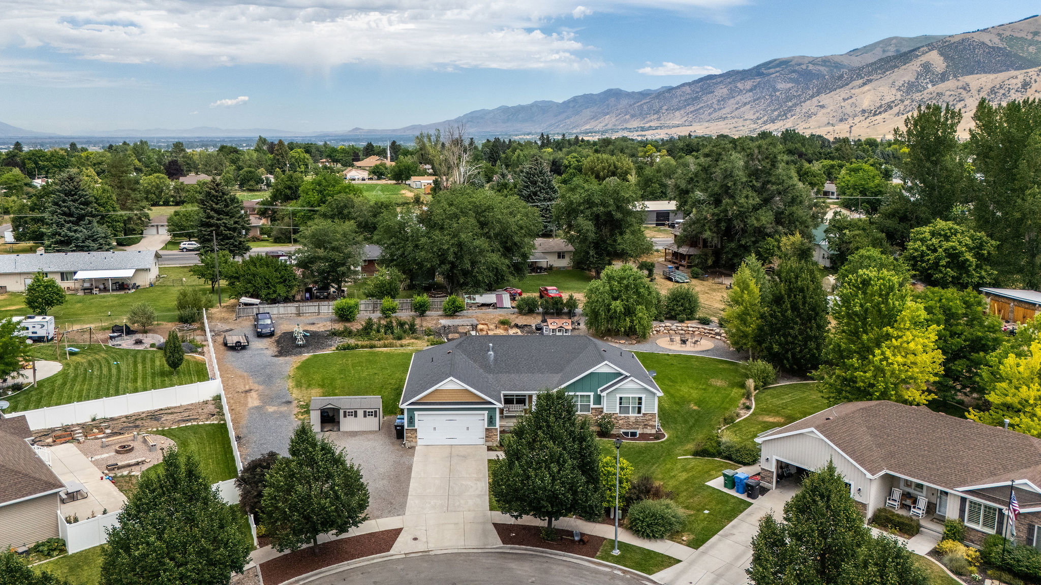 Ranch-style residence featuring a two-car garage, manicured front lawn, and mature landscaping