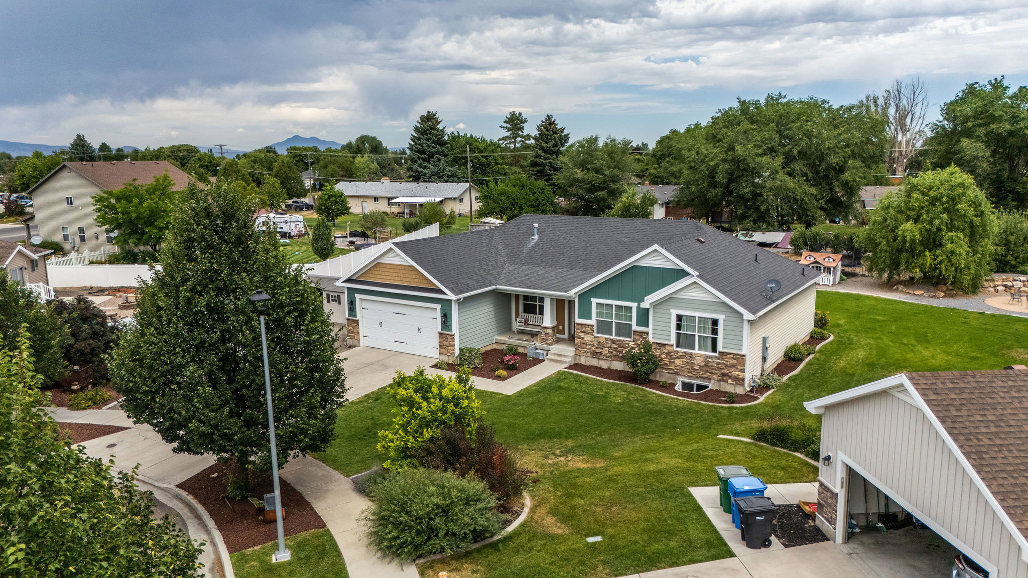 Contemporary exterior with a two-car garage, stone veneer accents, and a covered porch