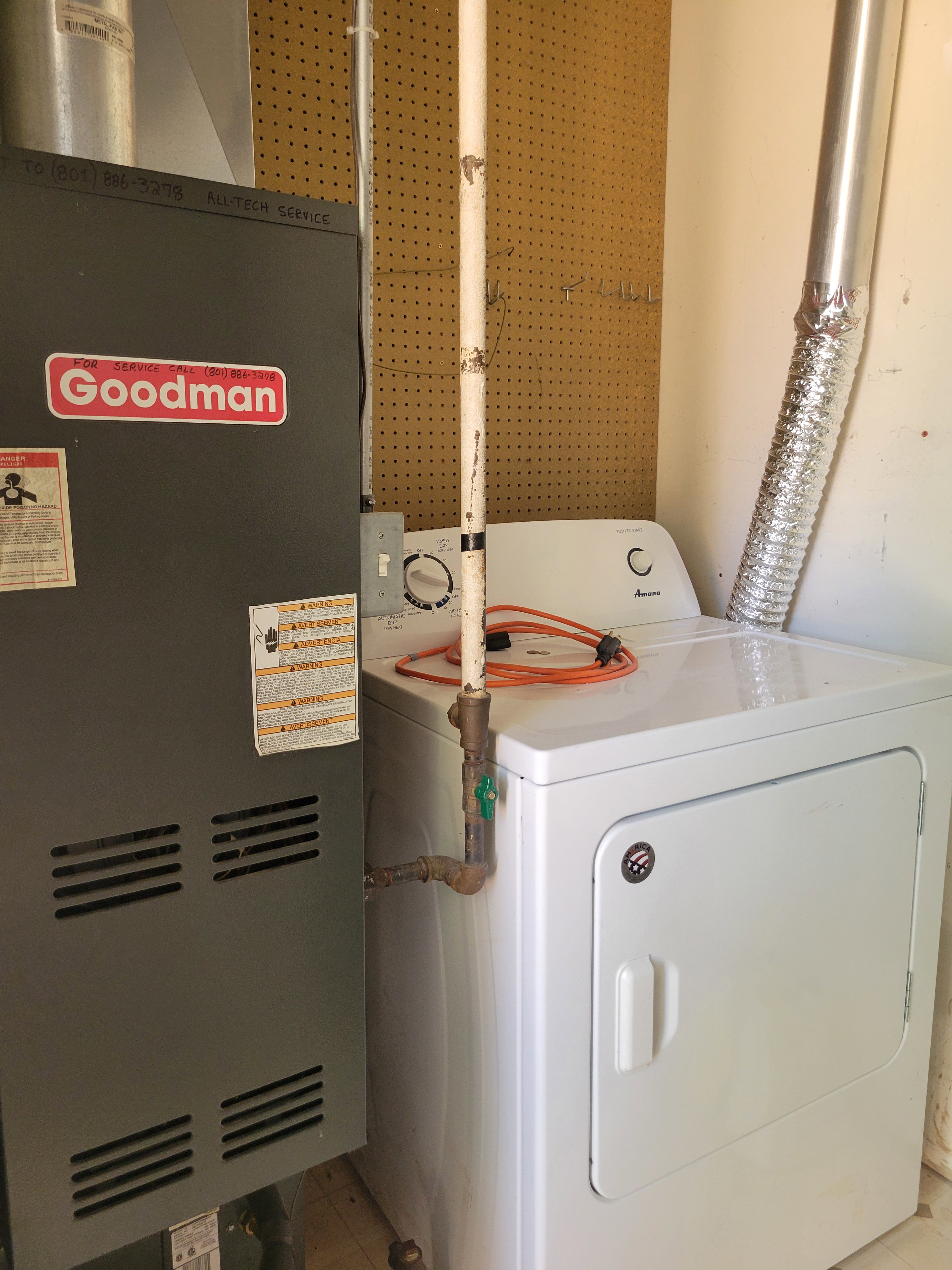 Dedicated laundry area featuring a white electric dryer and adjacent furnace unit