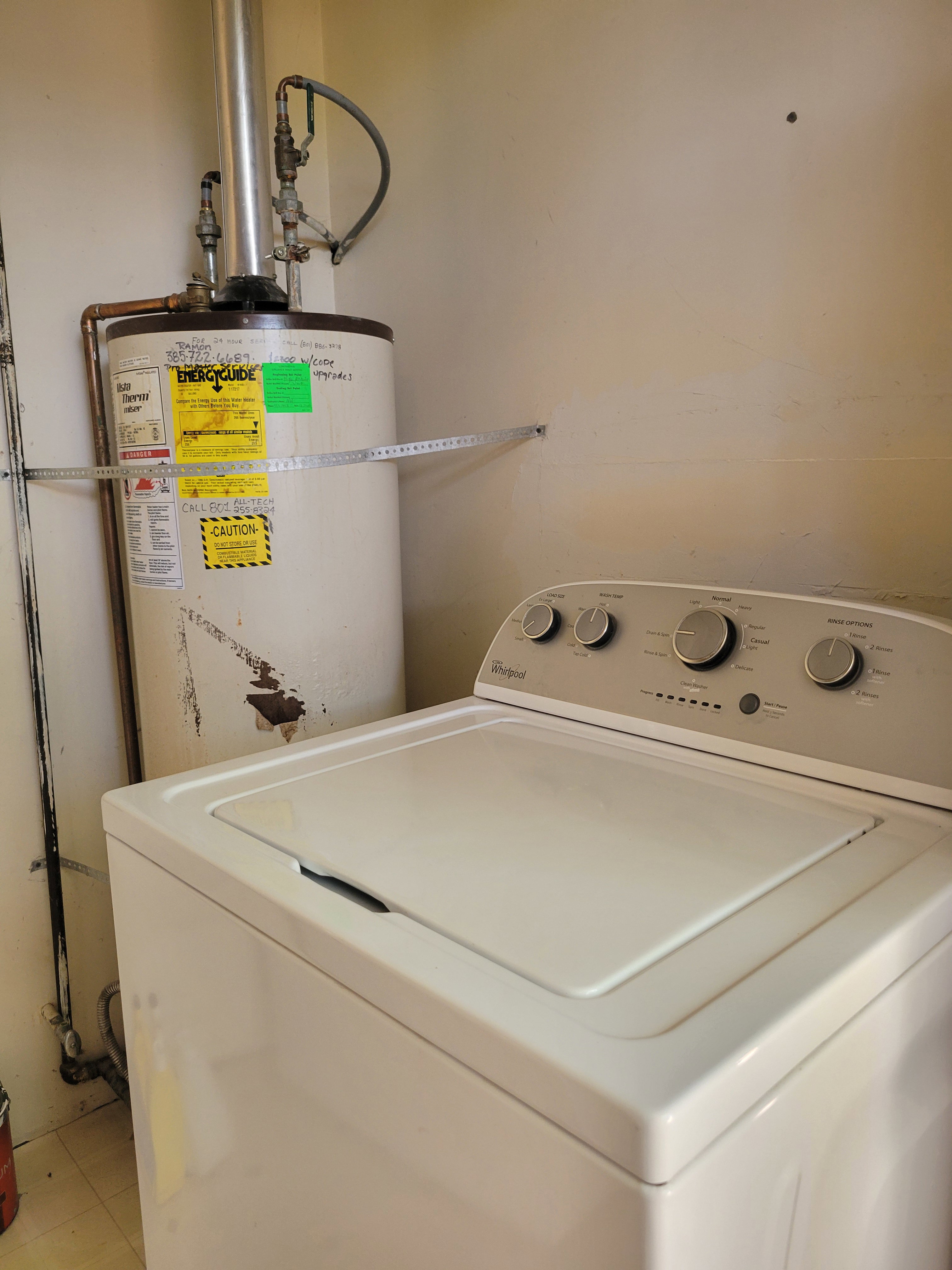 Utility area featuring a top-load washing machine and a water heater
