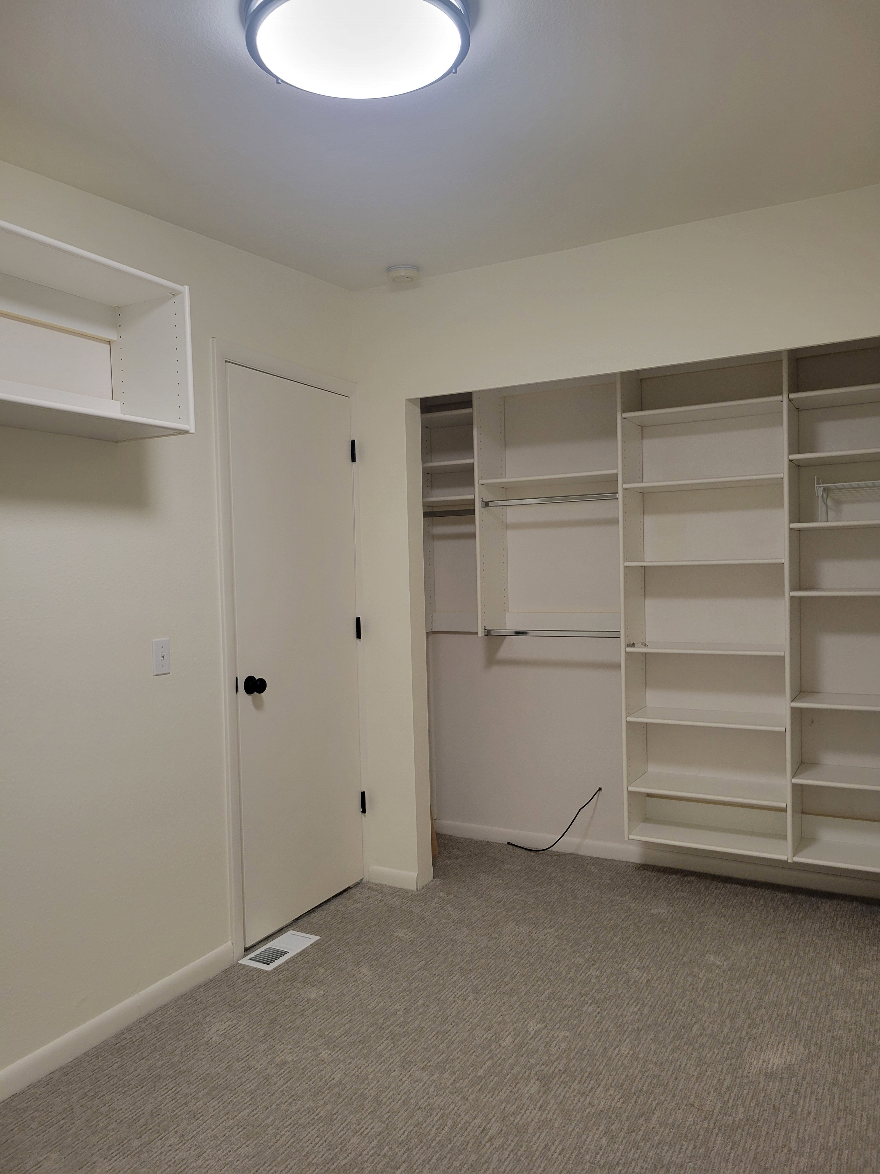 Another view of the second bedroom or office showing the closet and entry door.