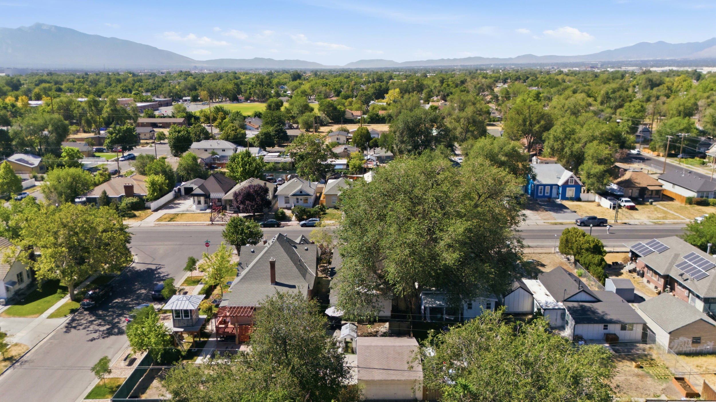 Residential neighborhood featuring mature trees, paved streets, and a mix of architectural styles