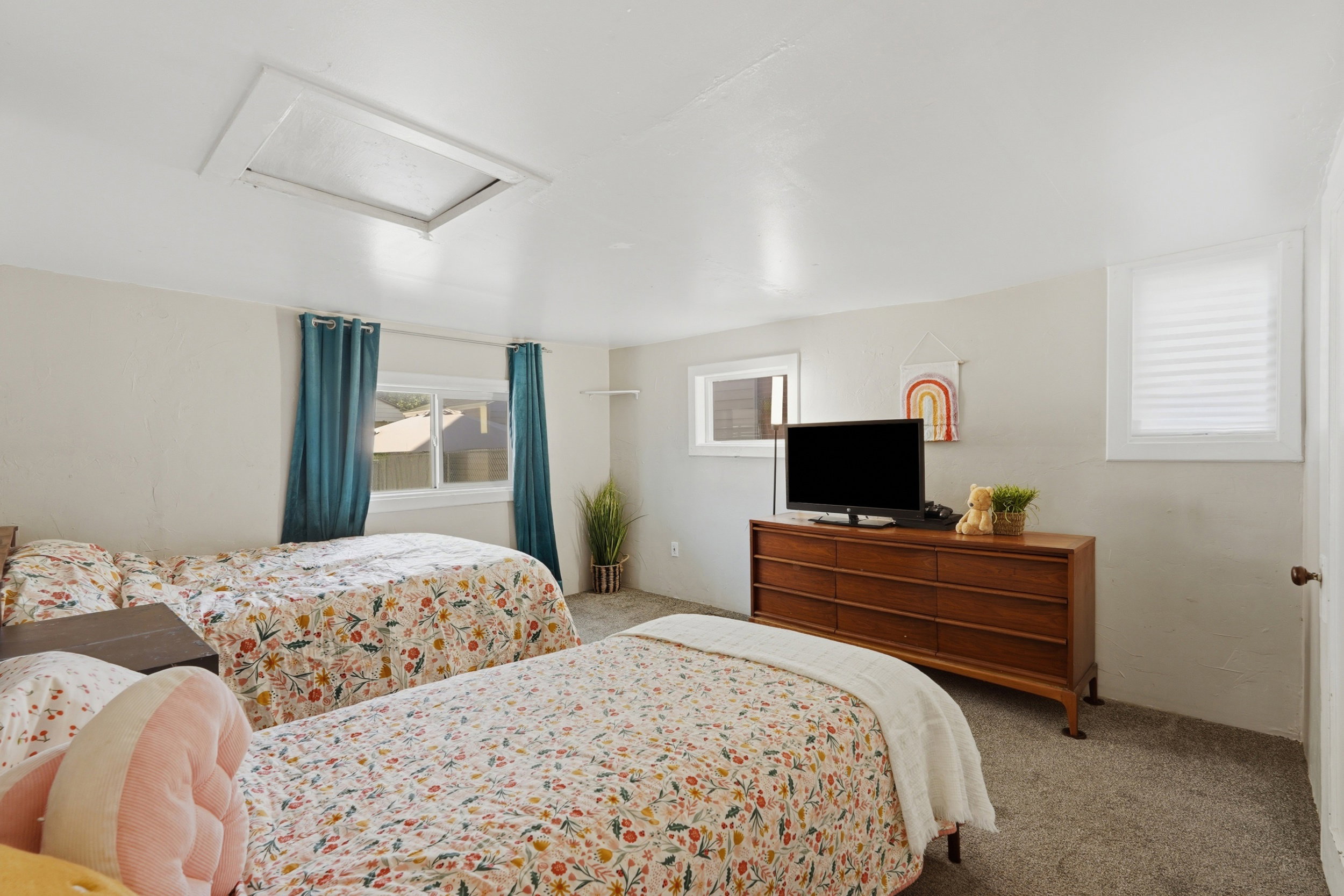Bedroom #3, Carpeted room with a ceiling-mounted skylight, two windows featuring white frames, and a third window with privacy blinds