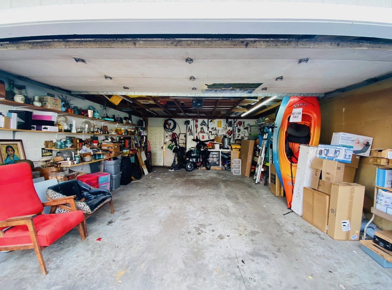 Spacious garage featuring concrete flooring and exposed ceiling joists