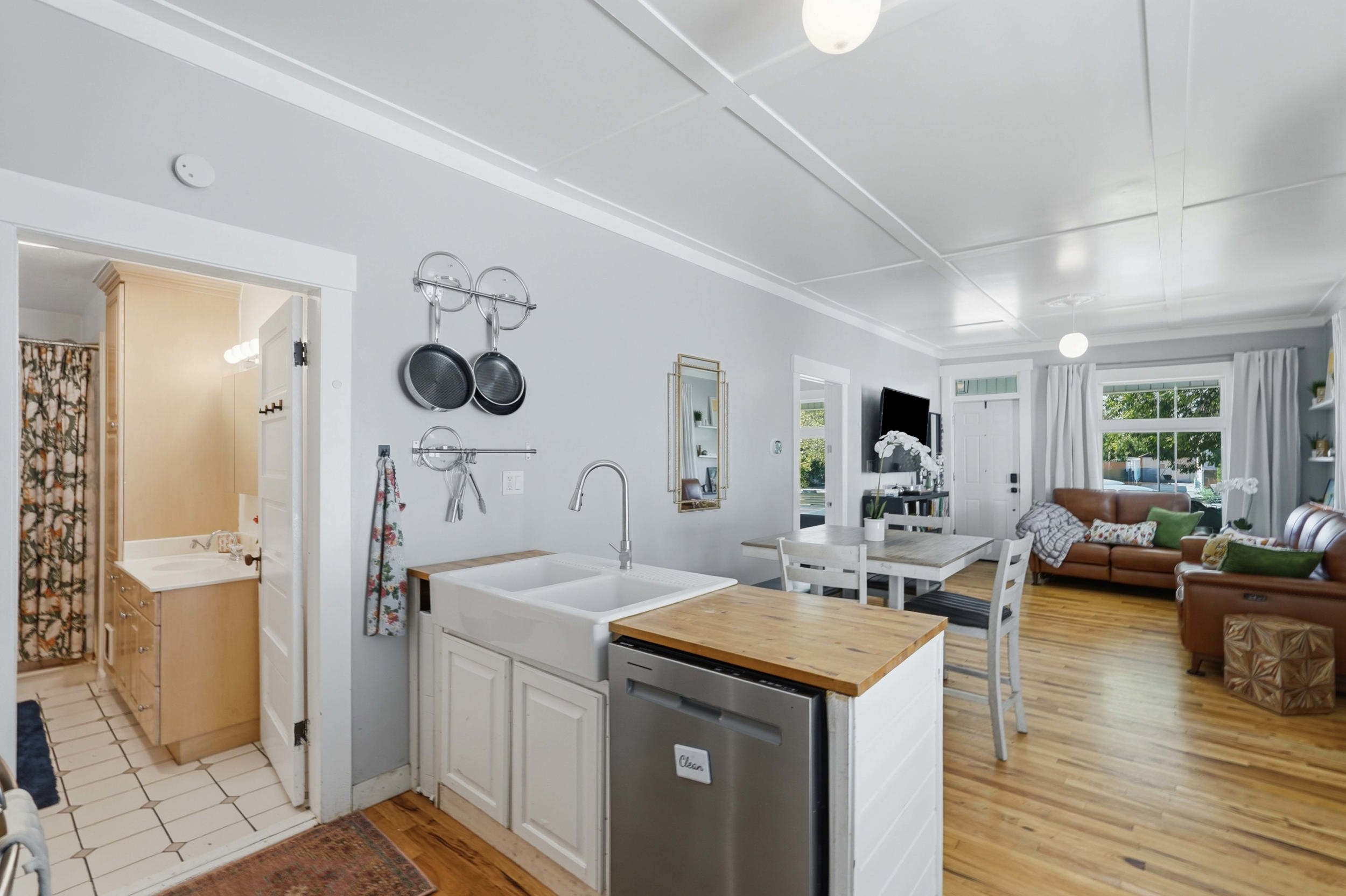 Open-concept living space with light-tone wood-finish flooring and a coffered ceiling