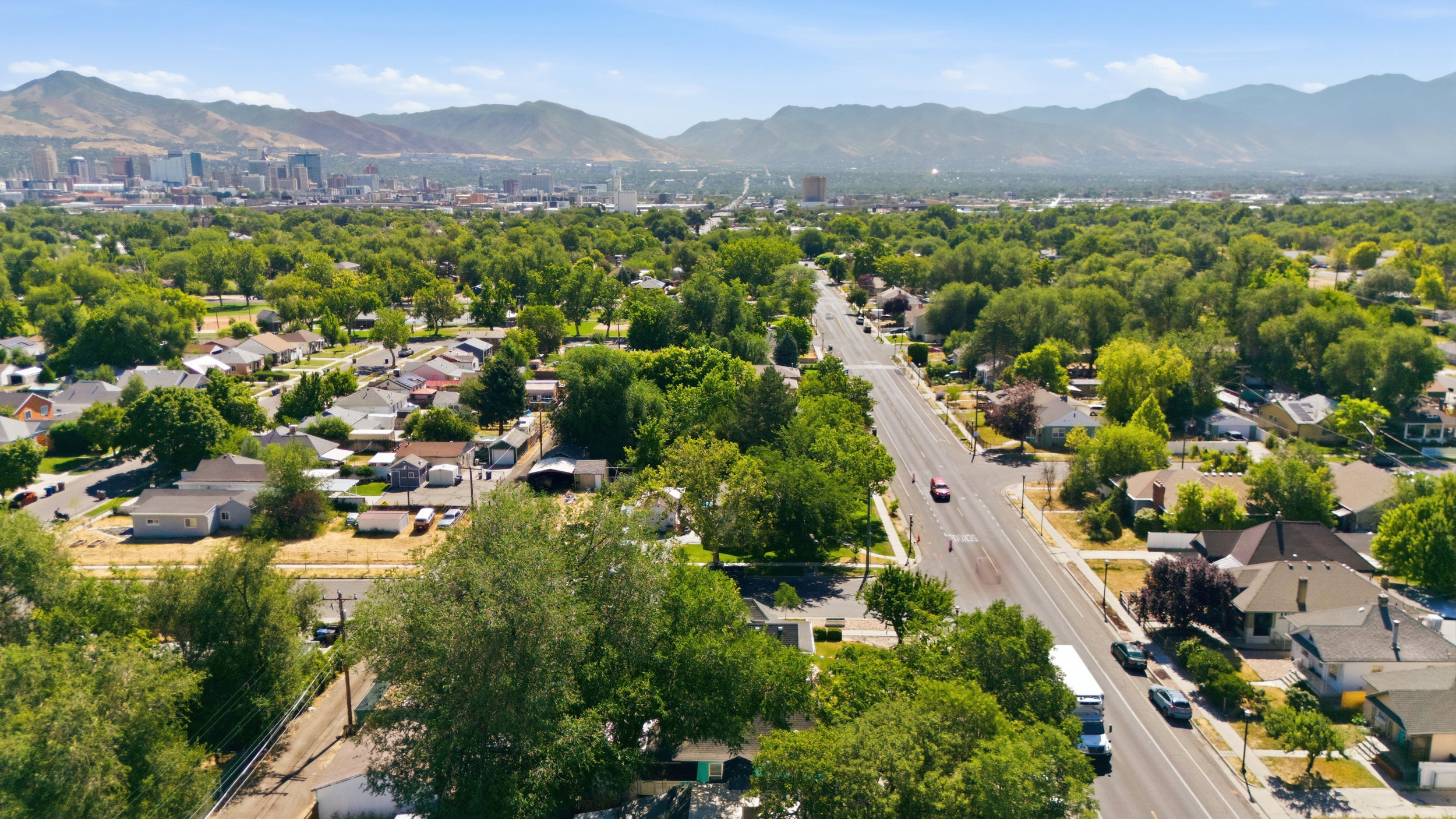 Expansive residential neighborhood featuring mature trees and a clear-day mountain backdrop