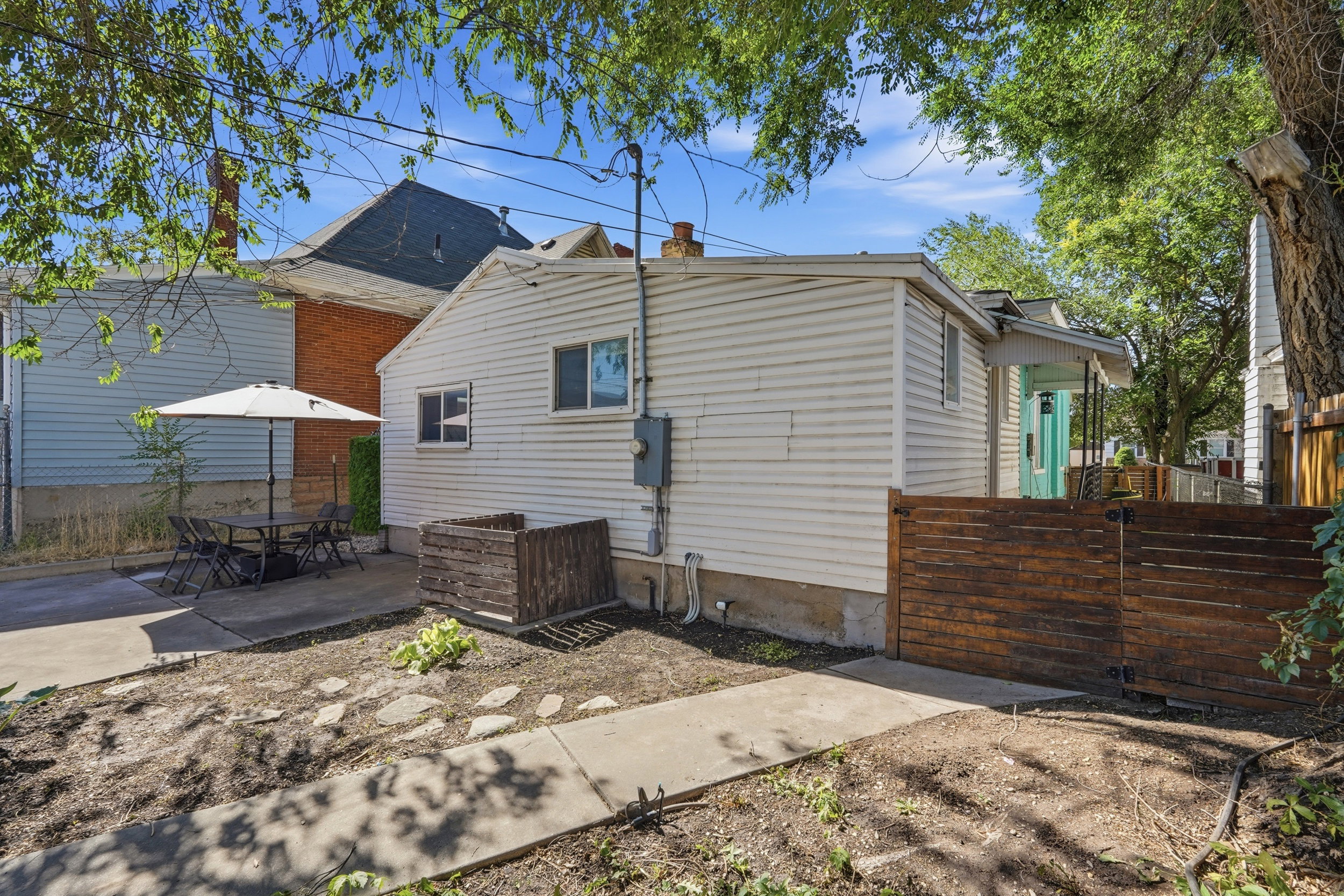 Rear exterior featuring white horizontal siding and a light turquoise entry door
