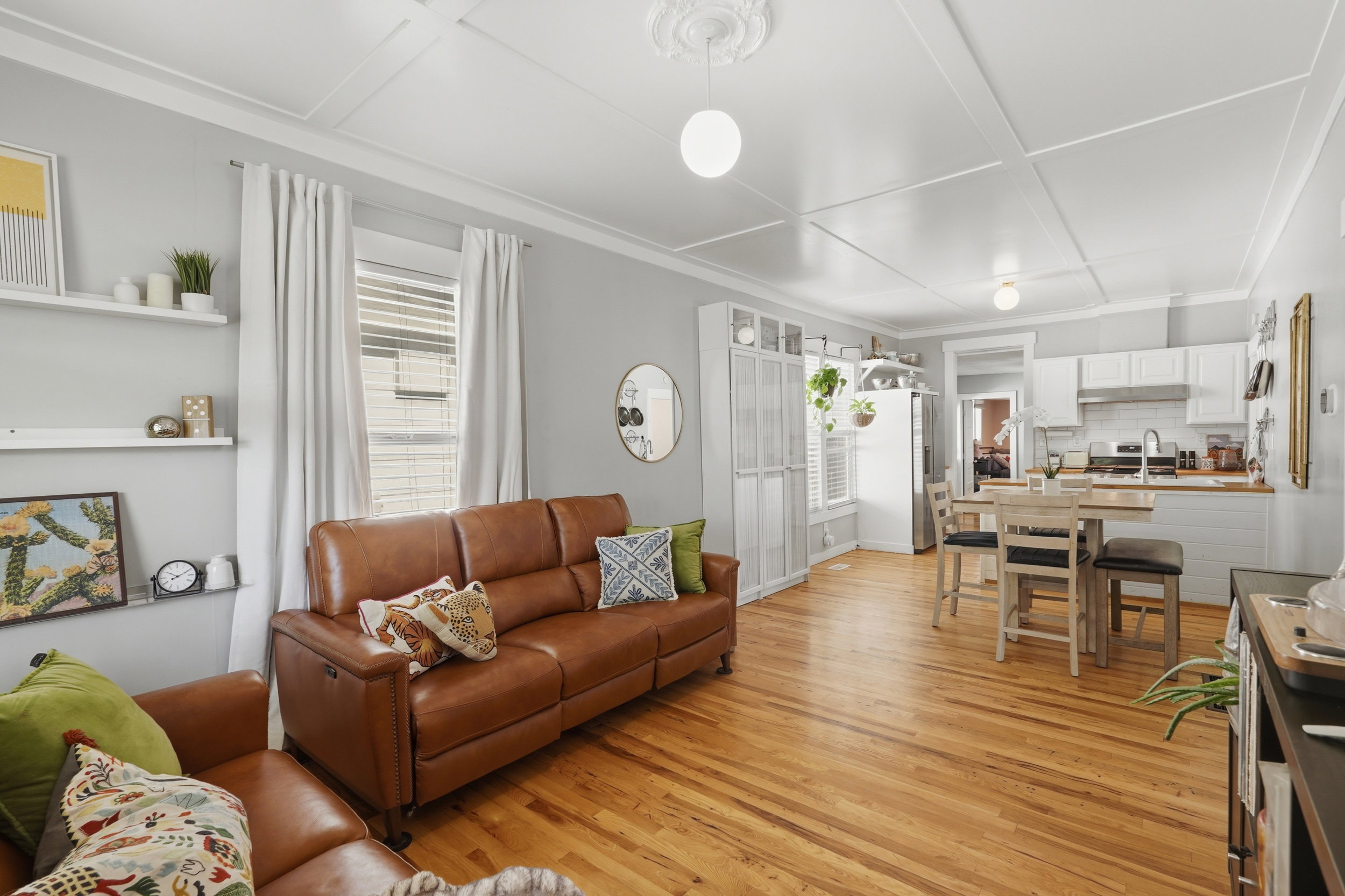 Open-concept living area featuring wood-finish flooring, a coffered ceiling, and recessed lighting