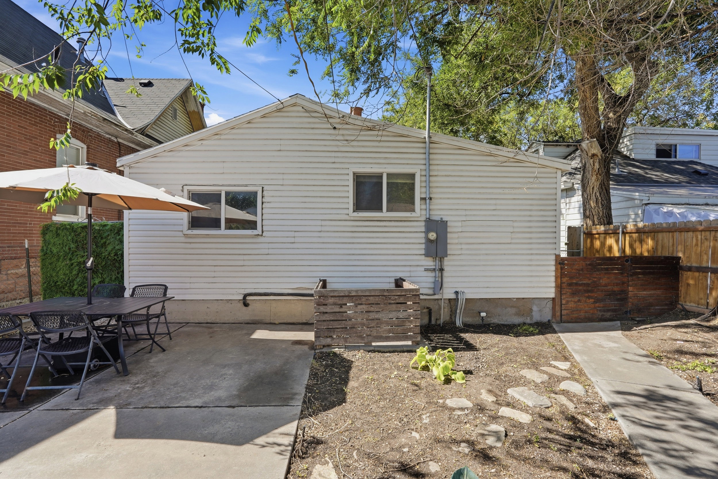 Rear exterior featuring white horizontal siding and a concrete patio