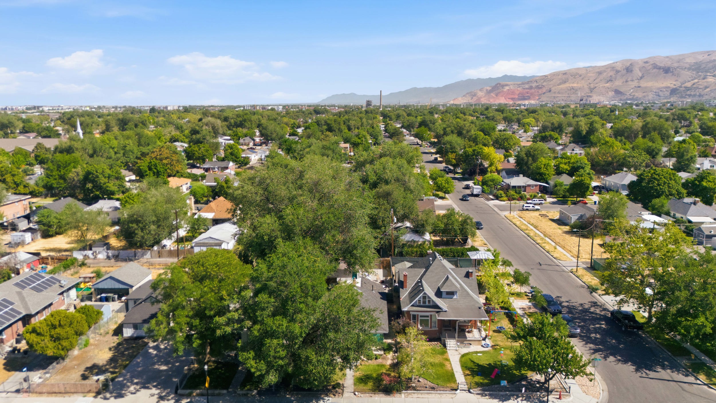 Aerial perspective showcasing a residential neighborhood with a variety of mature trees and established homes