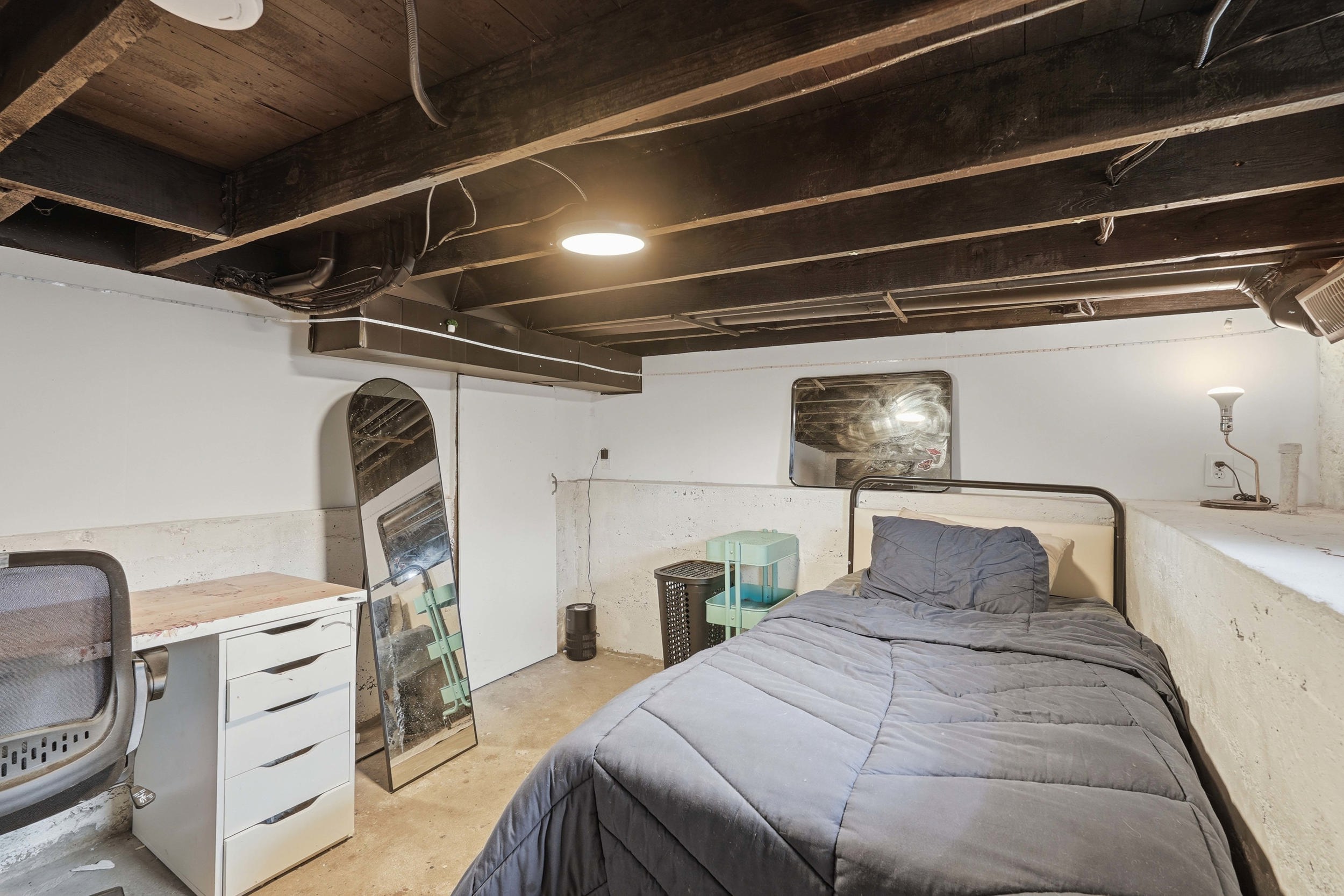 Basement downstairs, has room for flex space, exposed wood beam ceiling with recessed lighting.  (Remaining basement with furnace and water heater is behind access door.