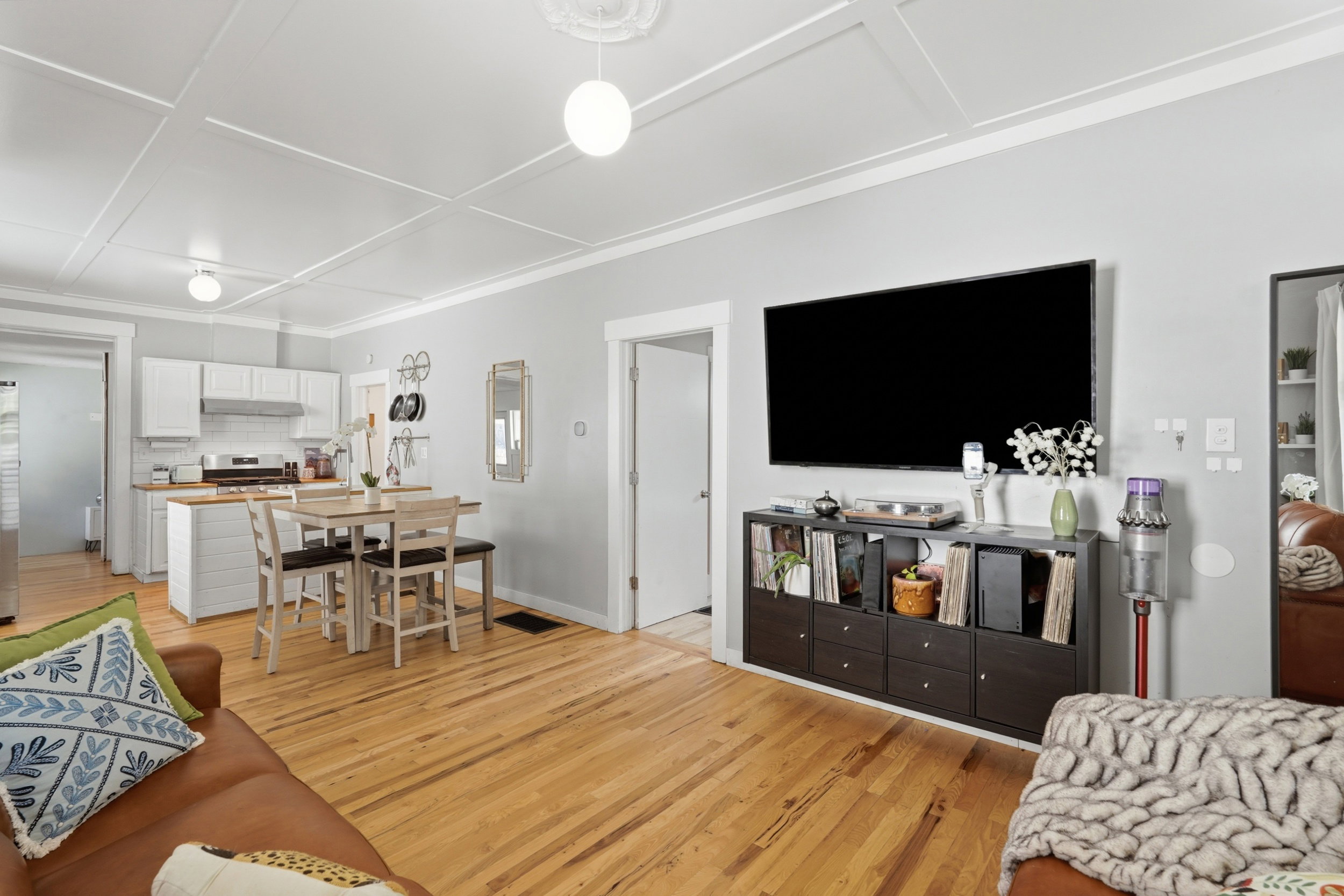 Open-concept living area with wood-finish flooring extending into the kitchen